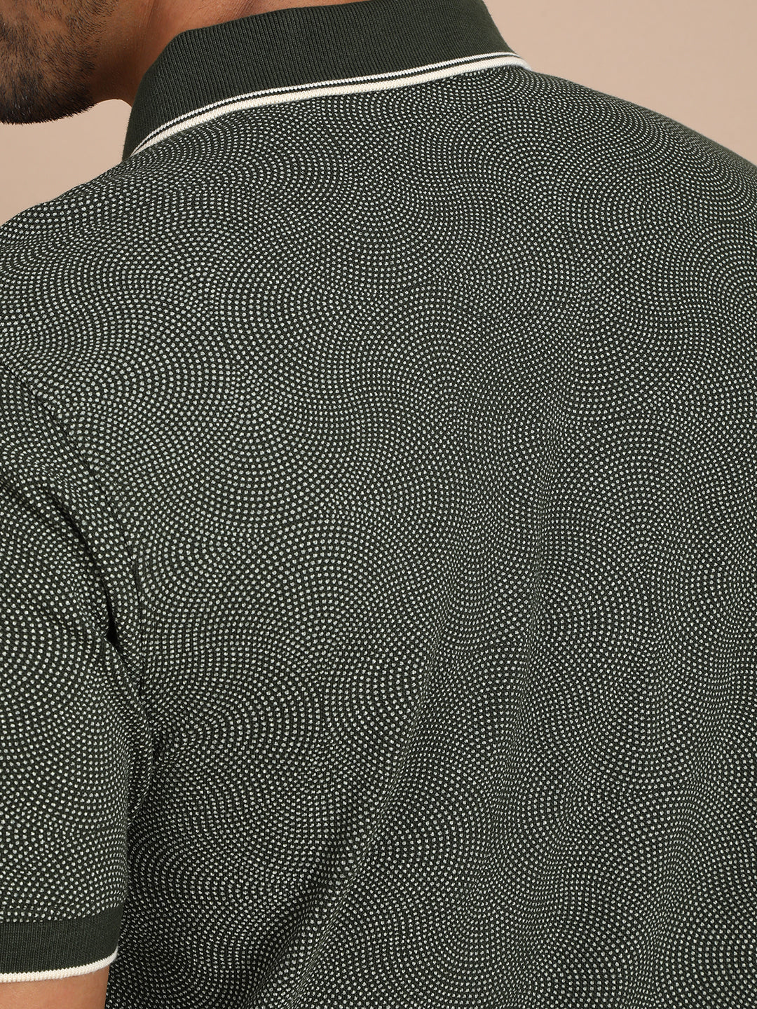Man wearing a green printed kombu green casual polo t shirt with casual styling on a gray background