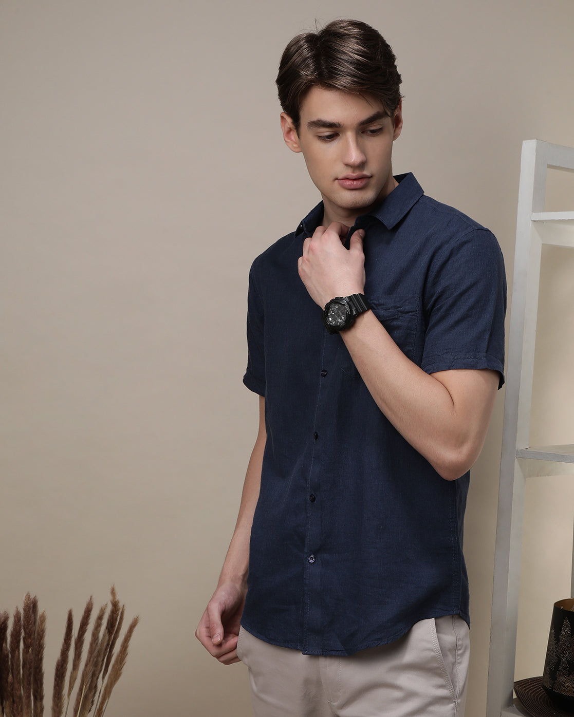 Man wearing a navy navy solid half sleeve linen shirt on a light gray background