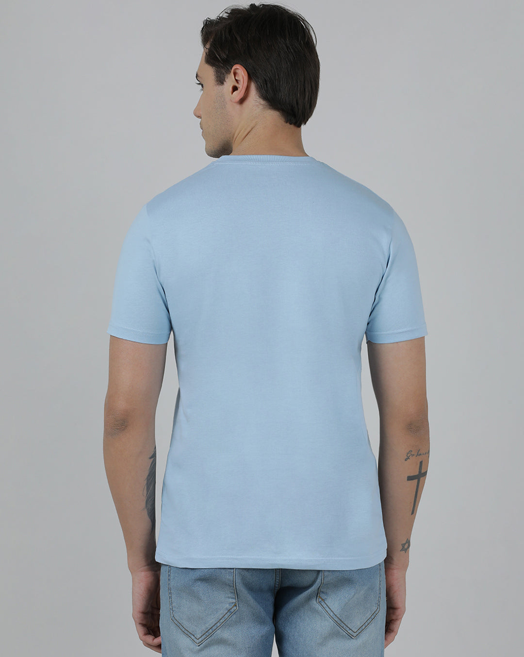 Man wearing a blue typography printed single jersey cotton t shirt blue on a light gray background