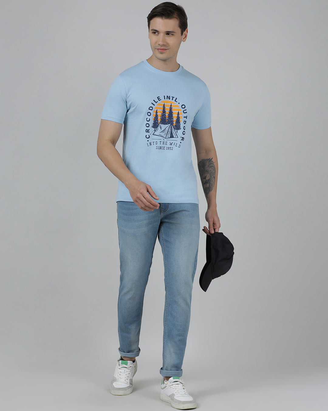 Man wearing a blue typography printed single jersey cotton t shirt blue on a light gray background