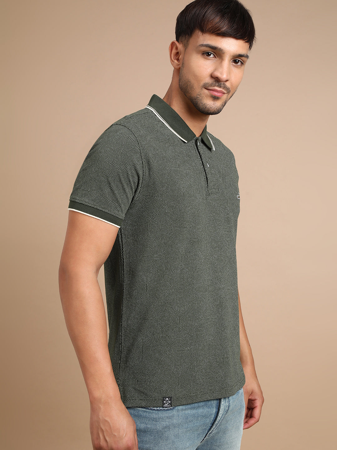 Man wearing a green printed kombu green casual polo t shirt with casual styling on a gray background