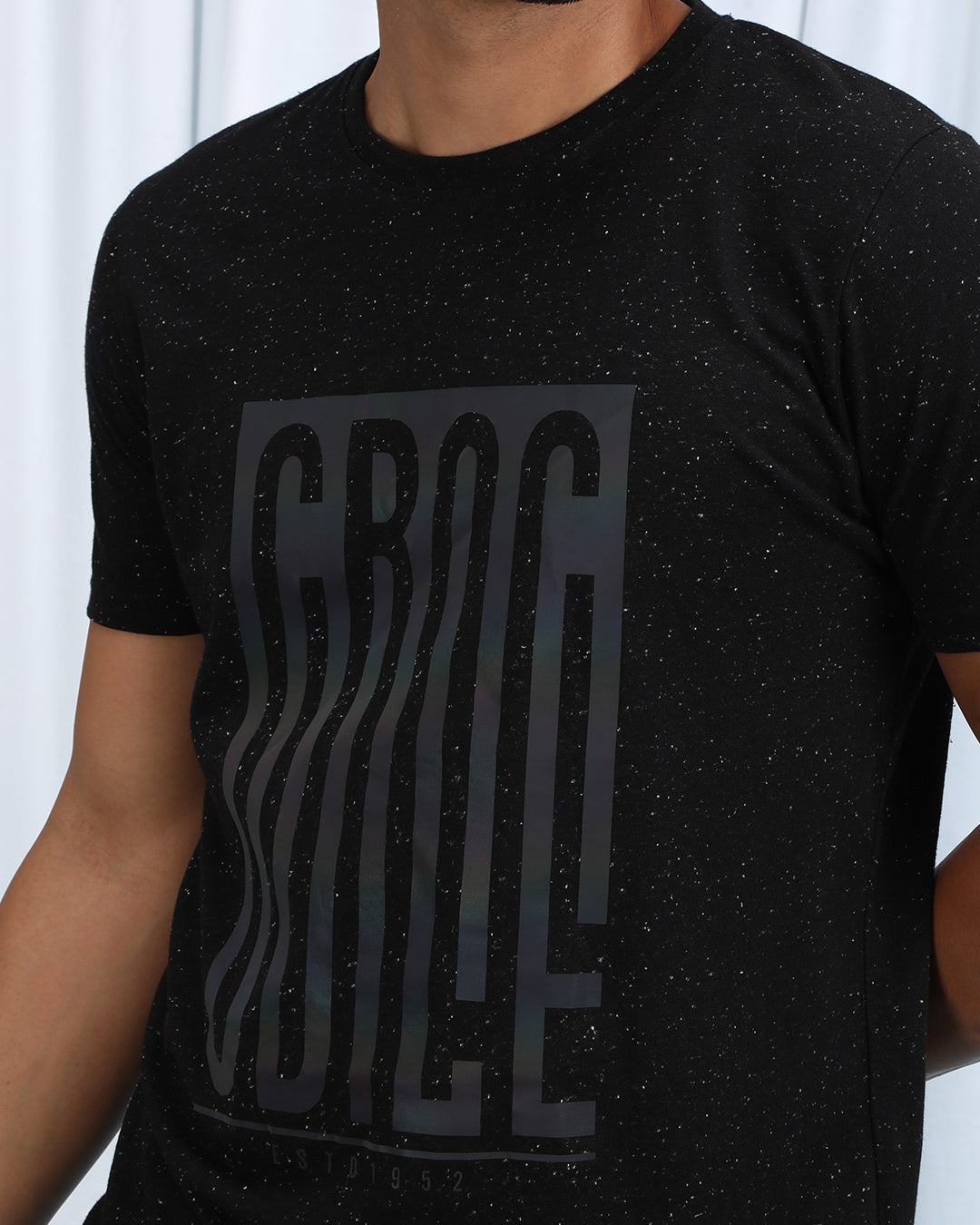 Man wearing a brown brown casual printed t shirt with casual styling on a gray background