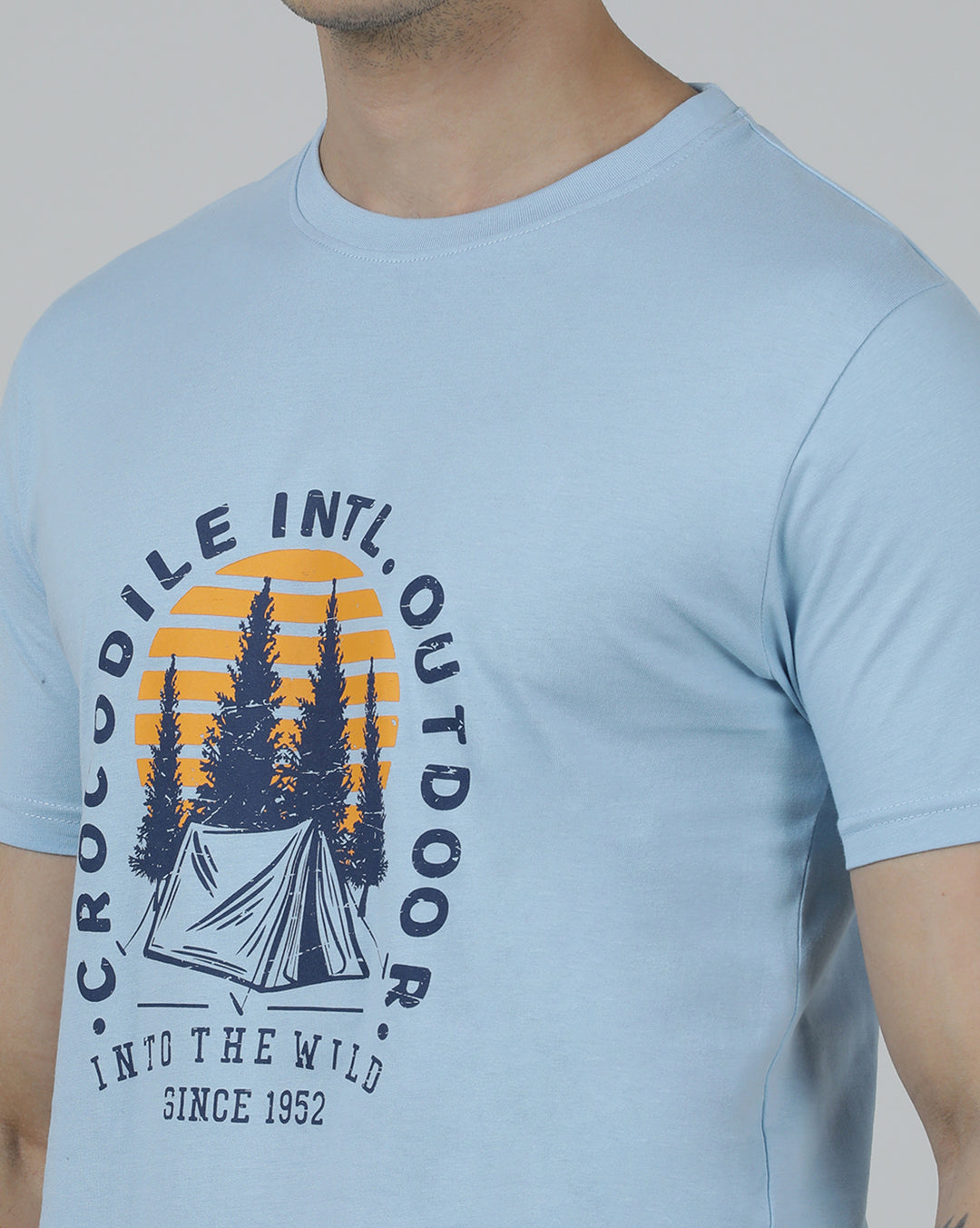 Man wearing a blue typography printed single jersey cotton t shirt blue on a light gray background