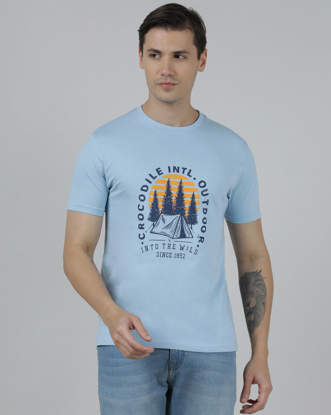 Man wearing a blue typography printed single jersey cotton t shirt blue on a light gray background