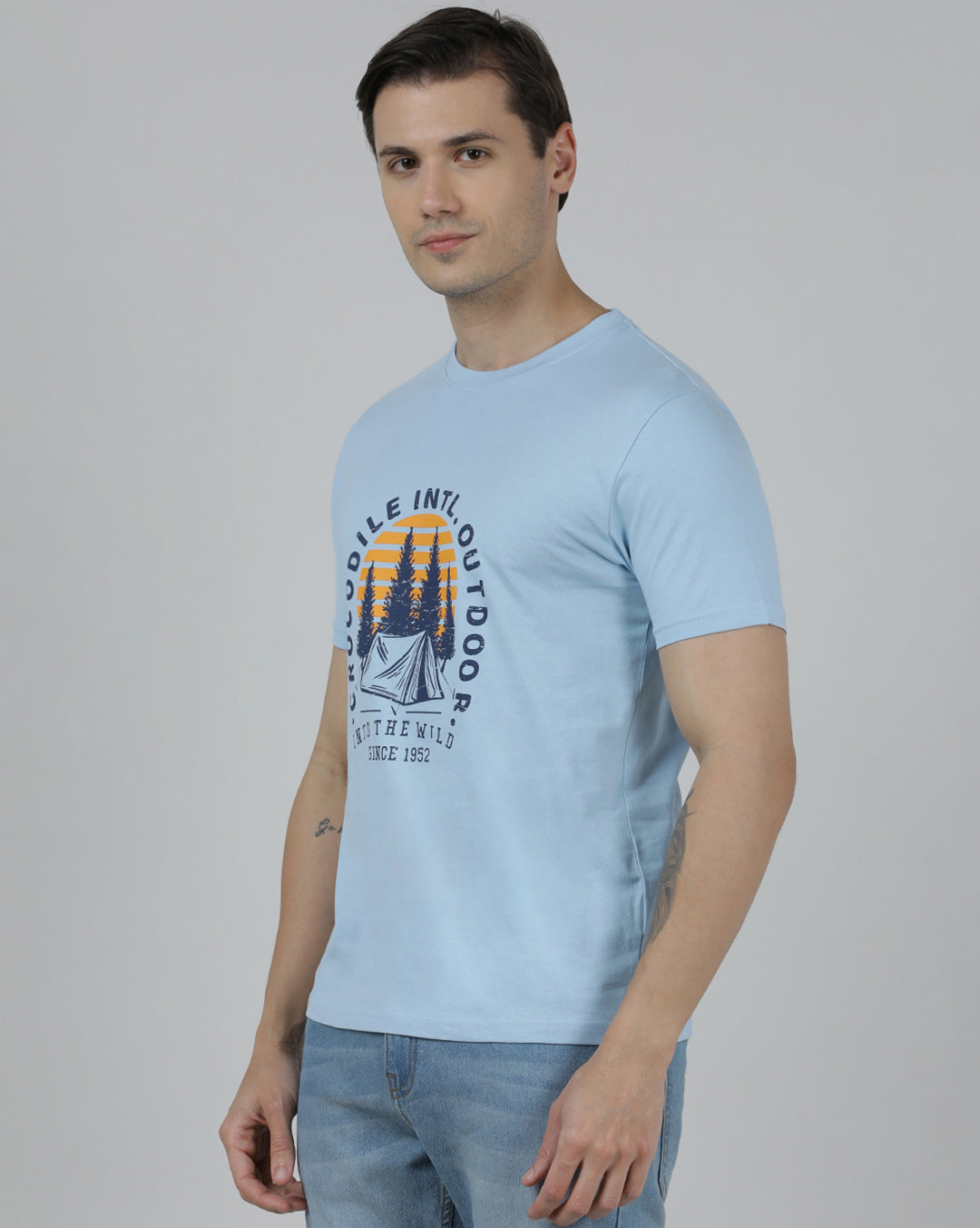Man wearing a blue typography printed single jersey cotton t shirt blue on a light gray background