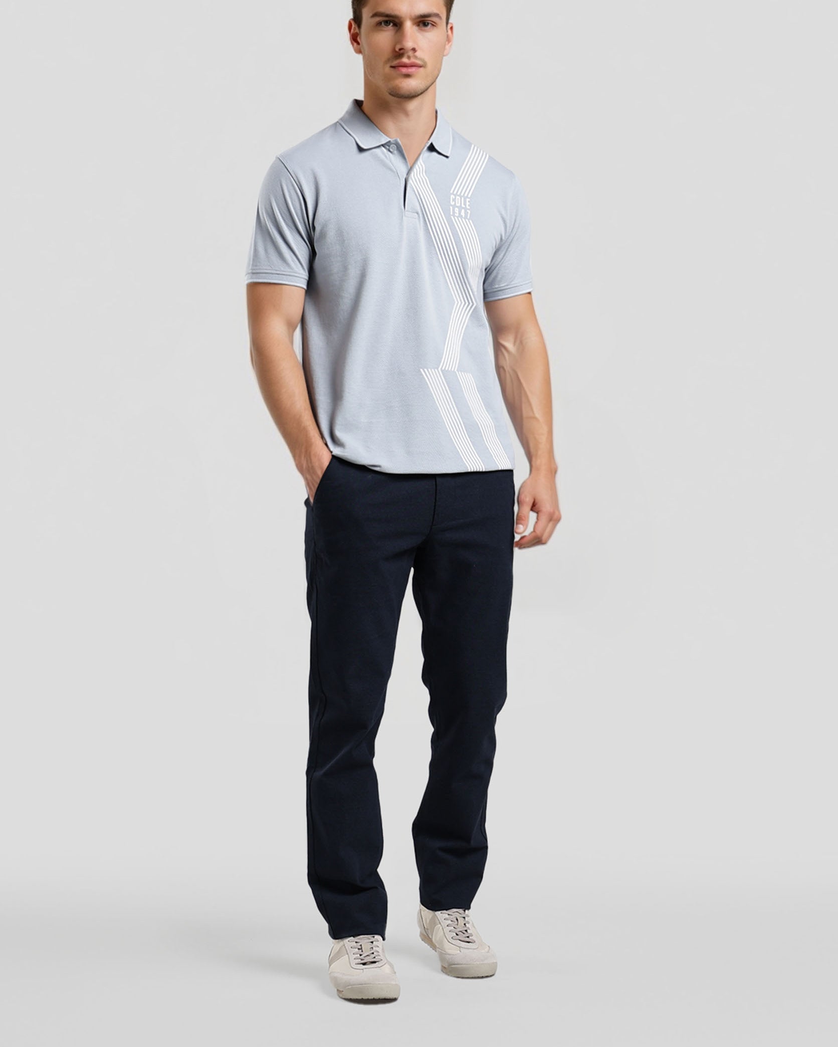 Man wearing a light gray polo shirt and dark pants on a white background