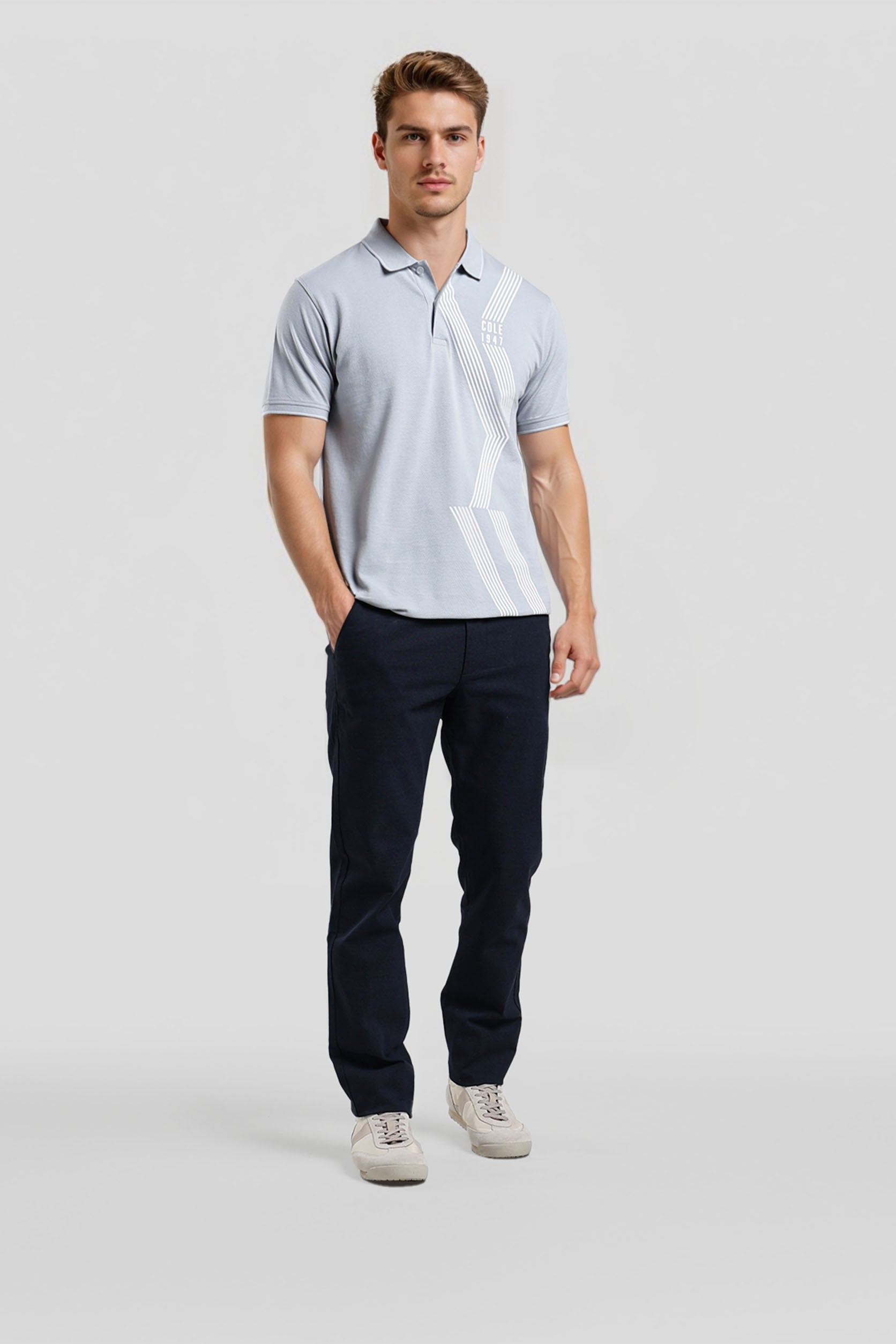 Man wearing a light gray polo shirt and dark pants on a white background