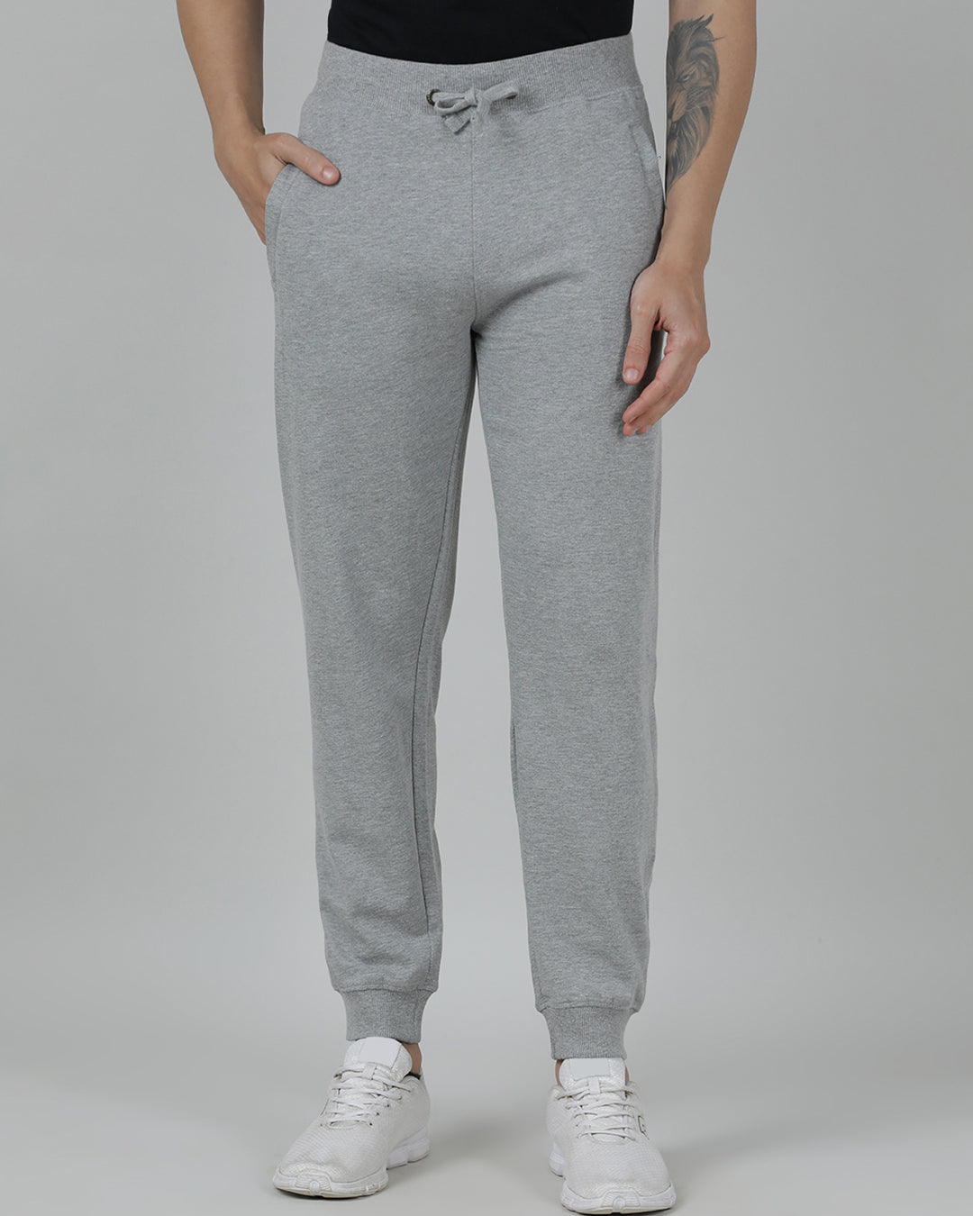 Person wearing gray sweatpants on a plain background