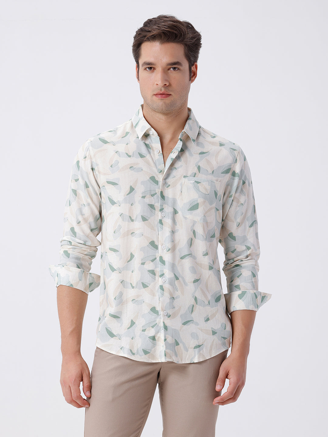 Man wearing a abstract leaf print linen shirt with casual styling on a gray background