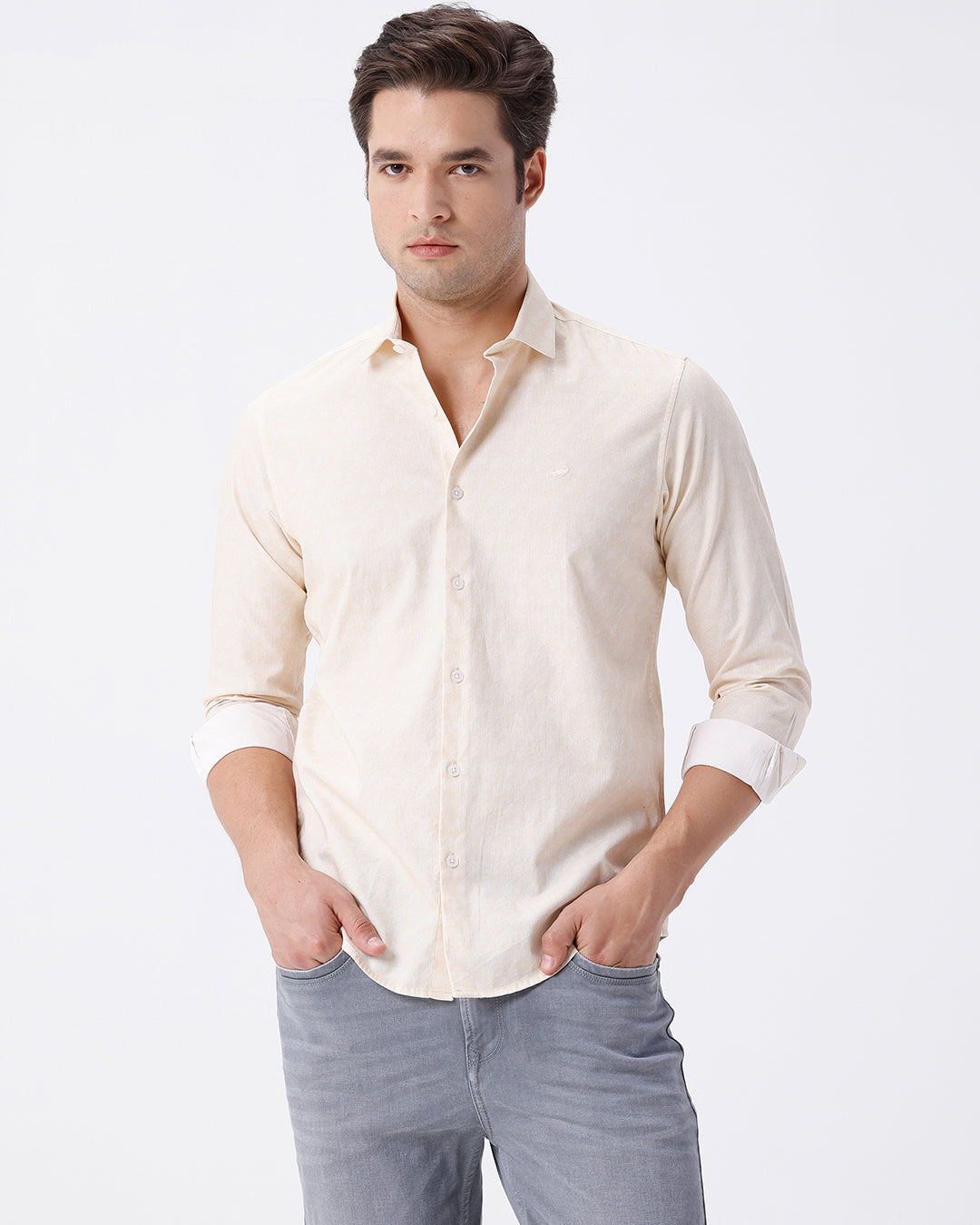 Man wearing a geomentic diamond print shirt on a light gray background