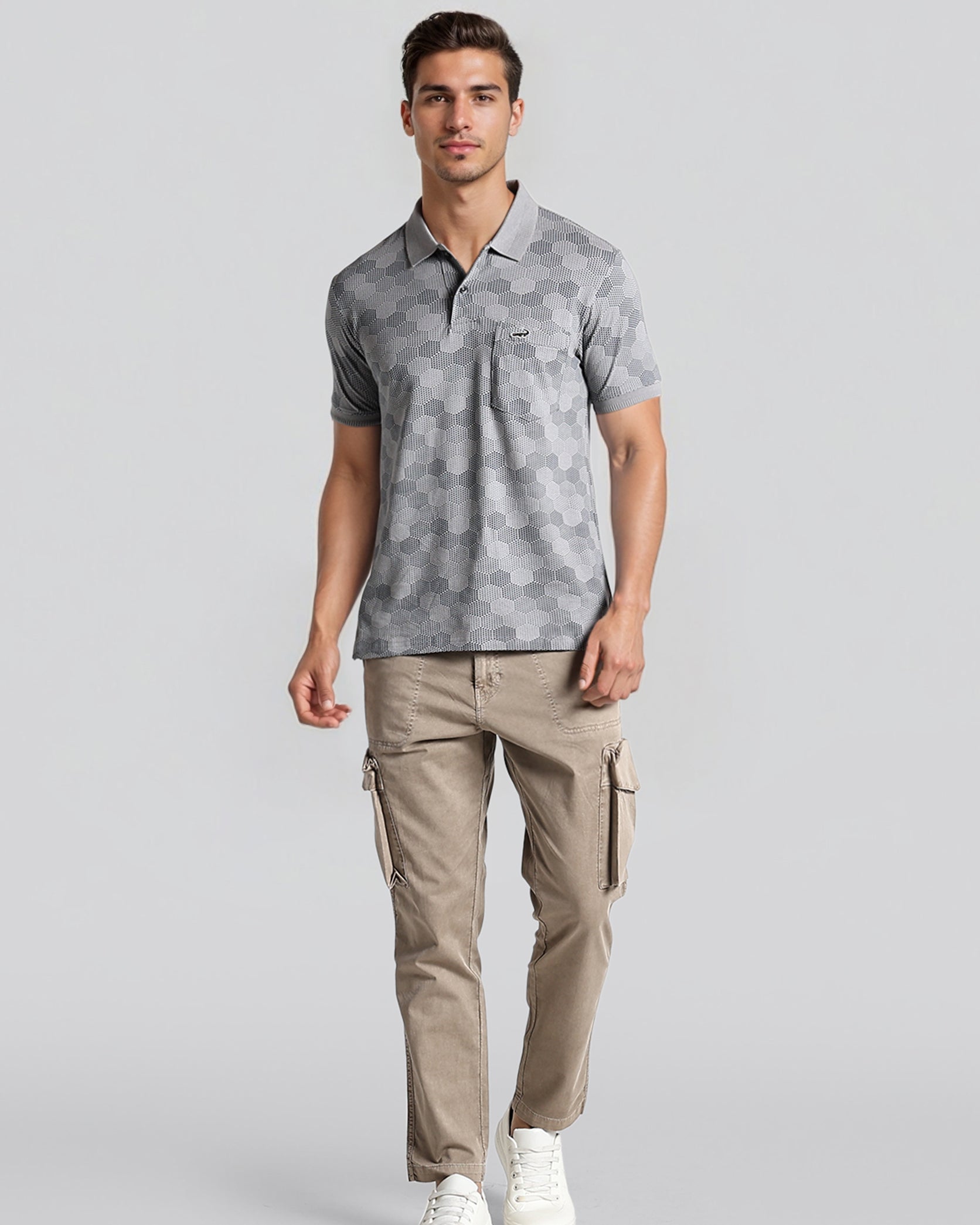 Man wearing a gray patterned polo shirt and beige cargo pants on a light gray background