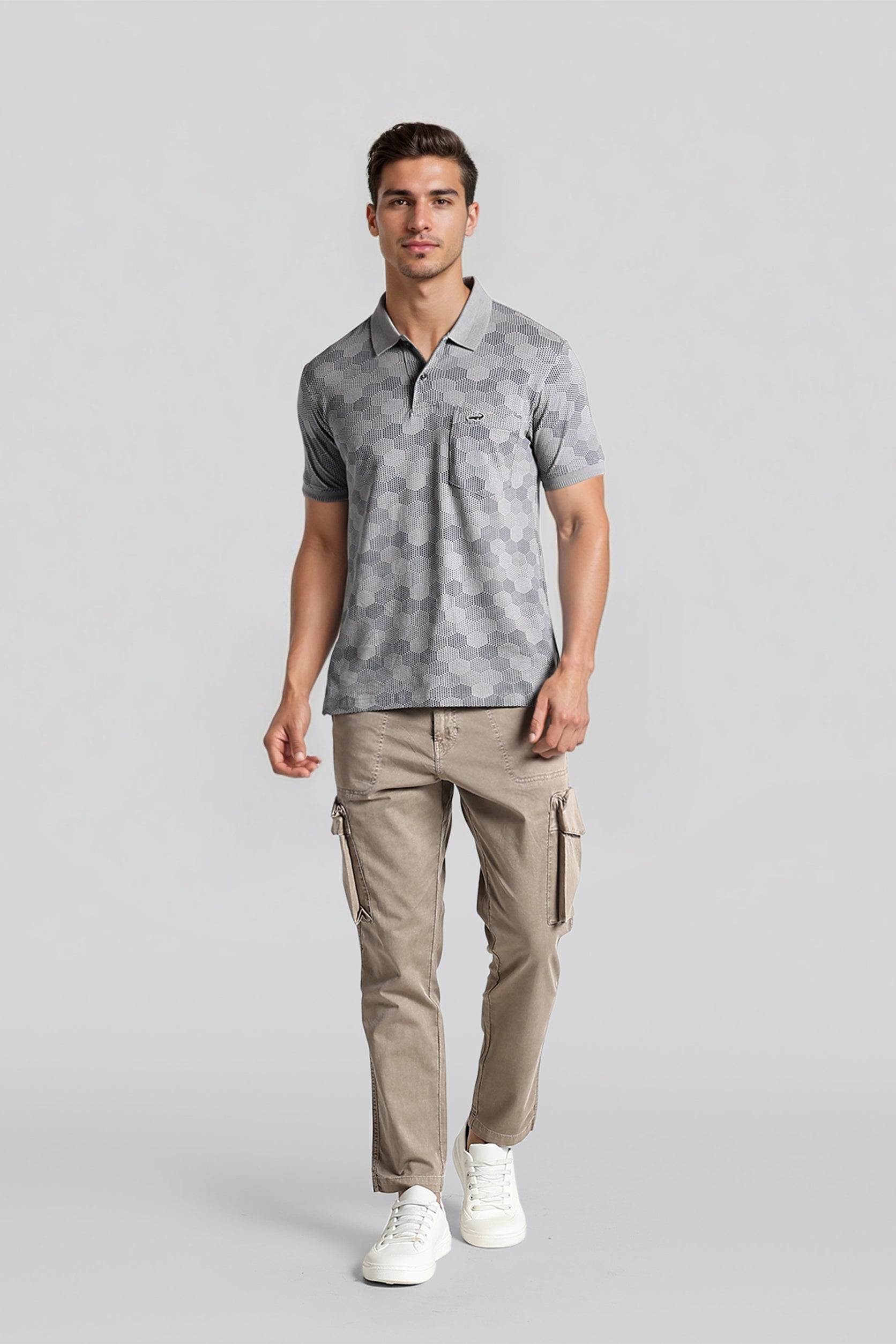 Man wearing a gray patterned polo shirt and beige cargo pants on a light gray background