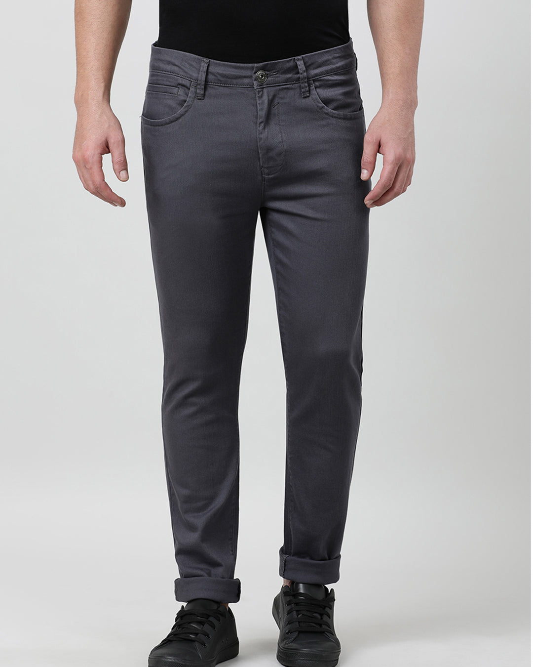 Man wearing a grey casual dark grey solid slim fit trouser with casual styling on a gray background