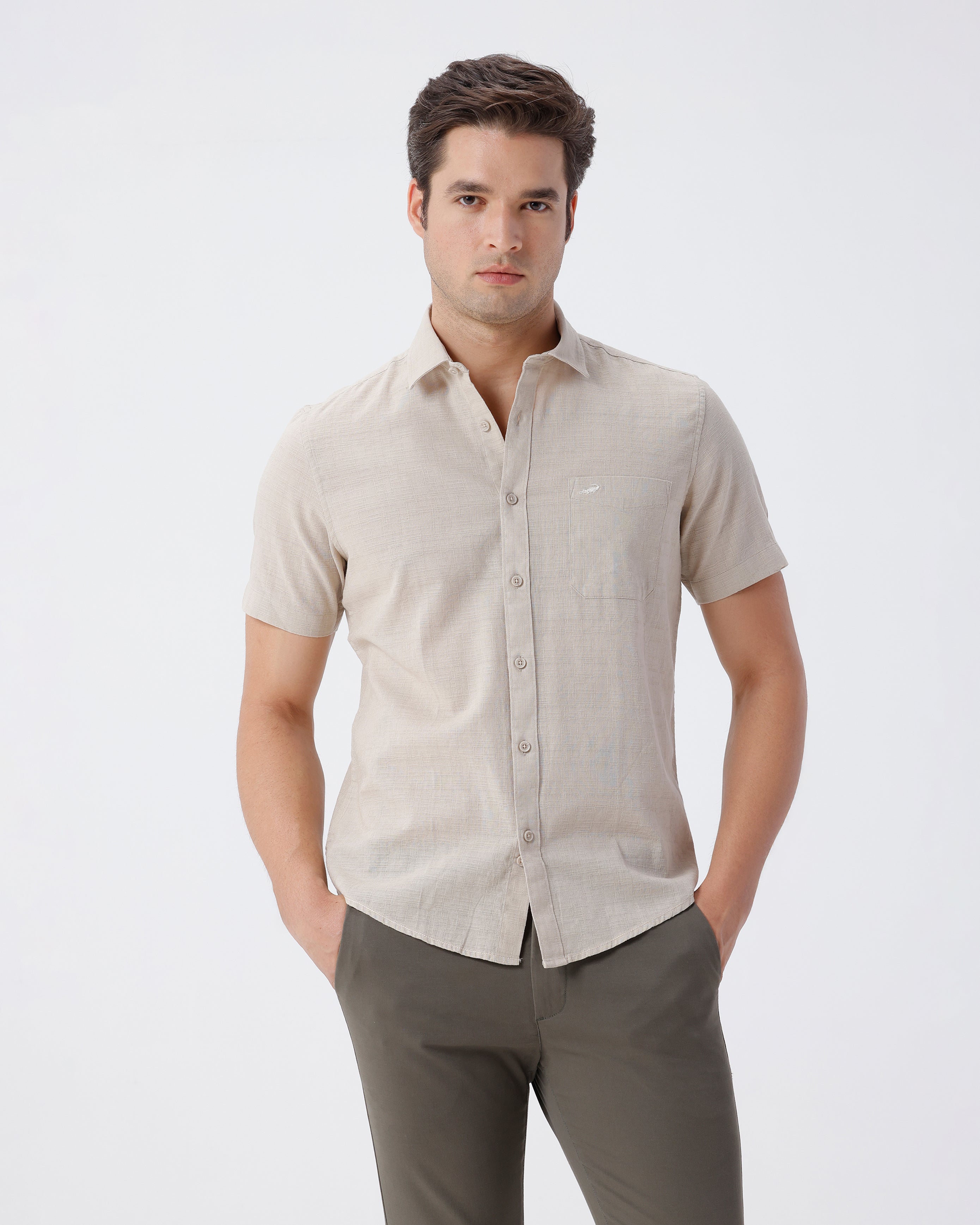 Man wearing a beige pure cotton textured shirt beige on a light gray background