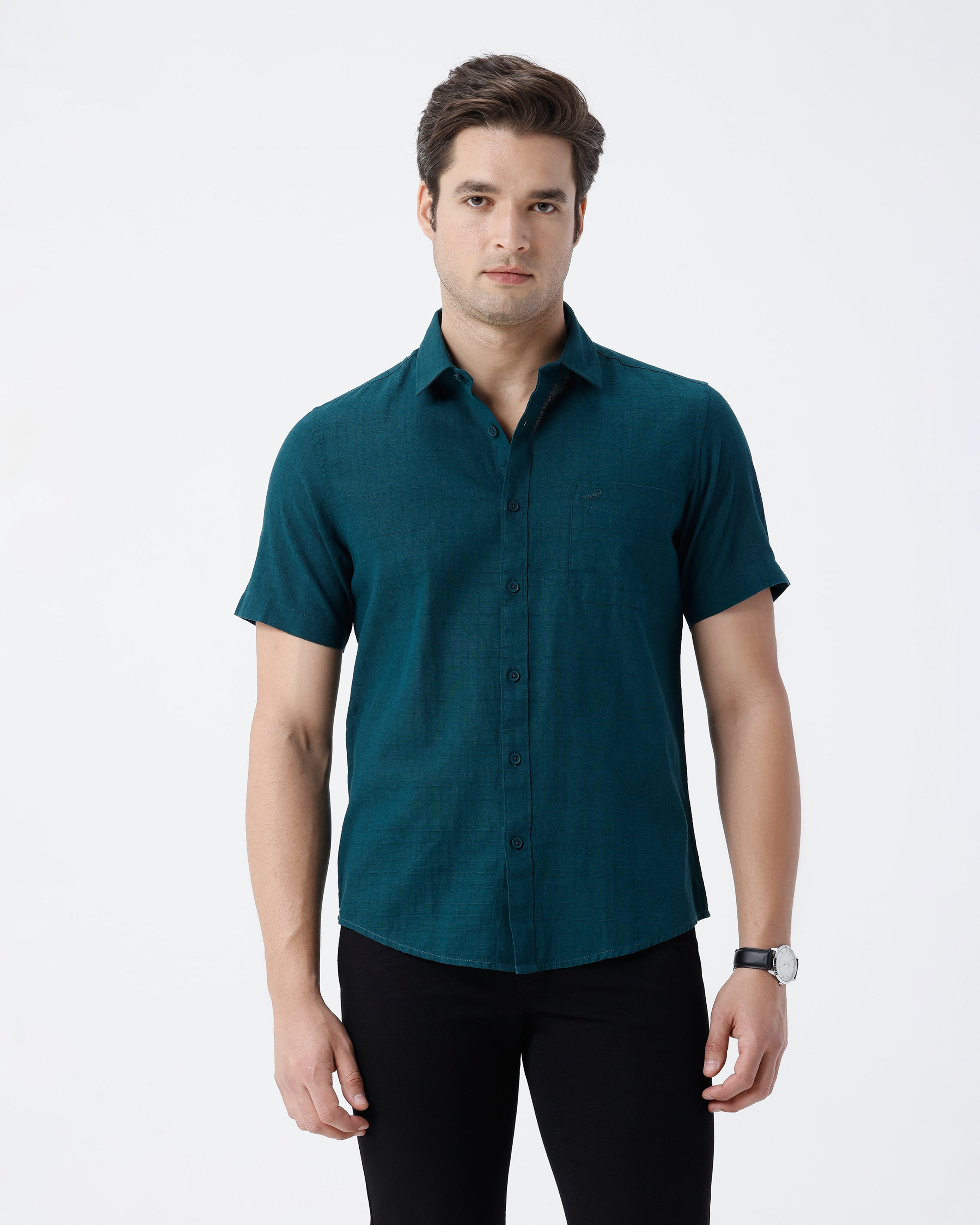 Man wearing a green pure cotton textured shirt green with casual styling on a gray background