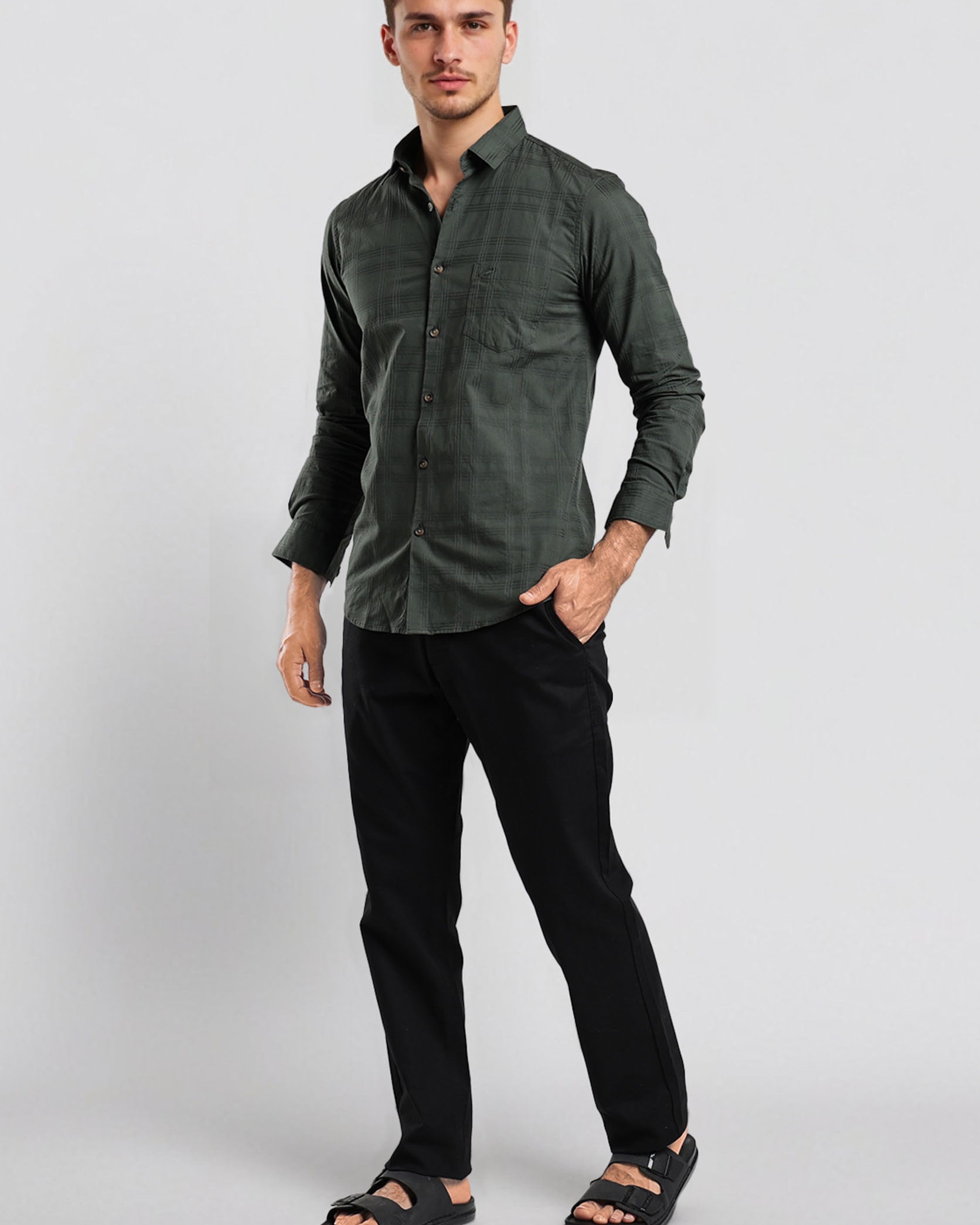 Man wearing a green shirt and black pants on a white background