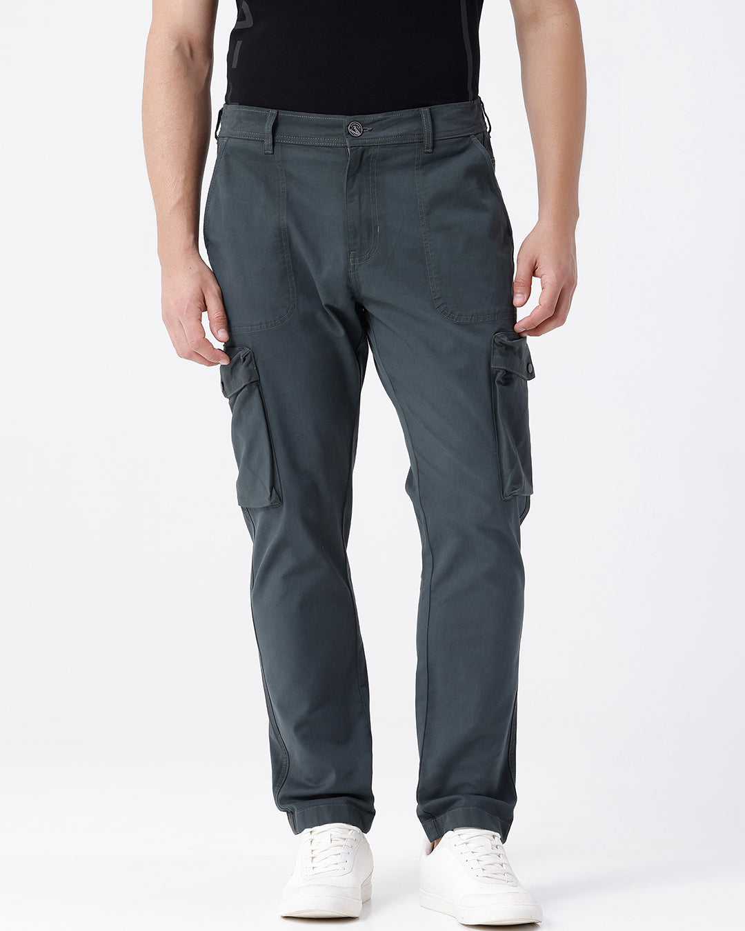 Man wearing a olive garment dyed cargo pant in olive with casual styling on a gray background