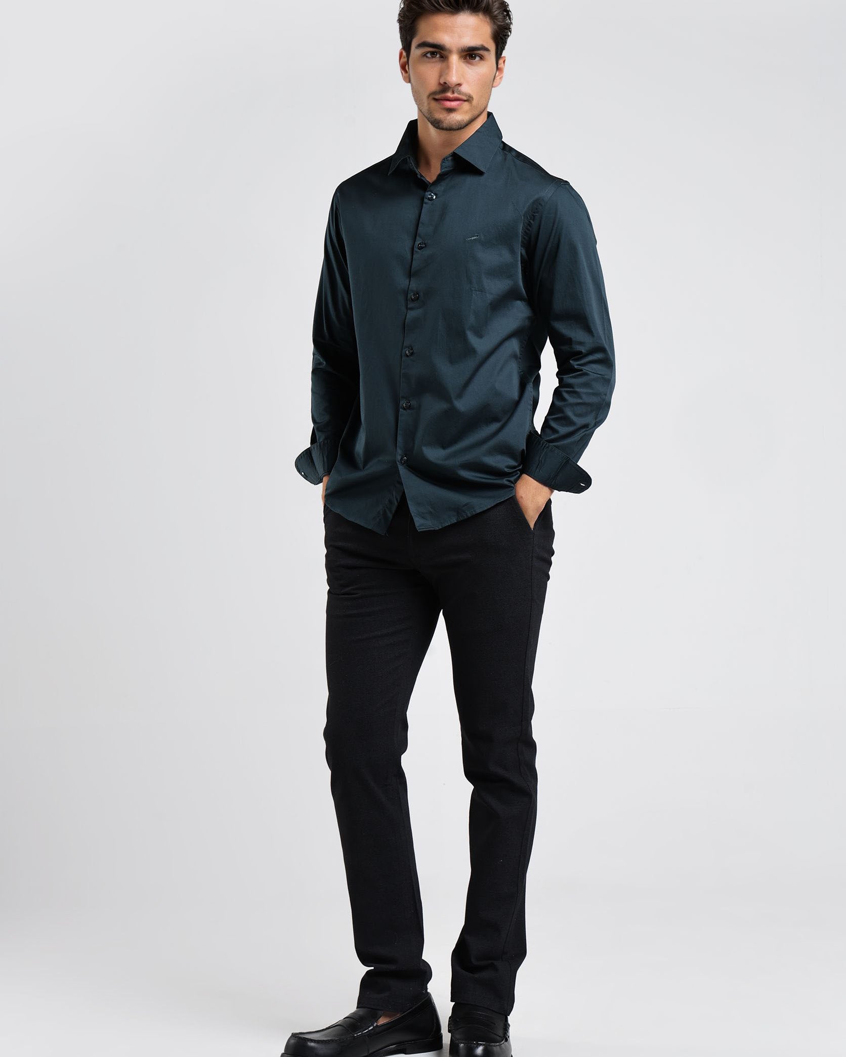 Man wearing a dark green shirt and black pants on a white background