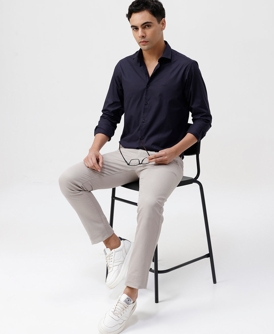 Man wearing a navy mercerized stretch shirt navy with casual styling on a gray background