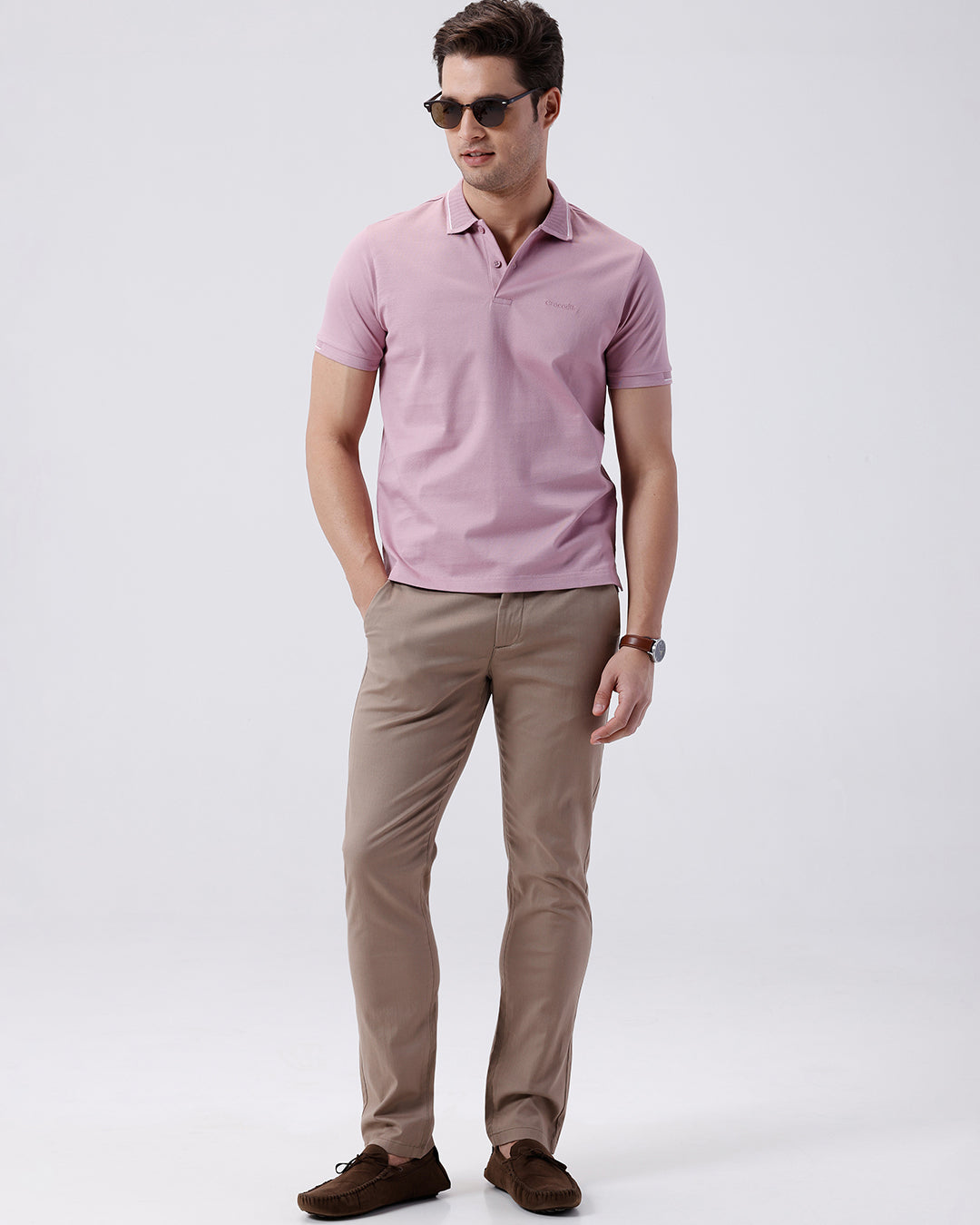 Man wearing a red mercerized subtle textured polo t shirt with casual styling on a gray background