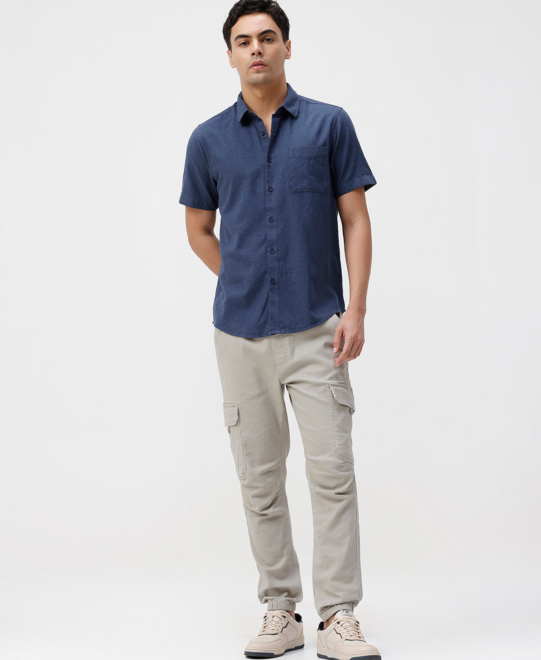Man wearing a blue melange shirt solid blue on a light gray background
