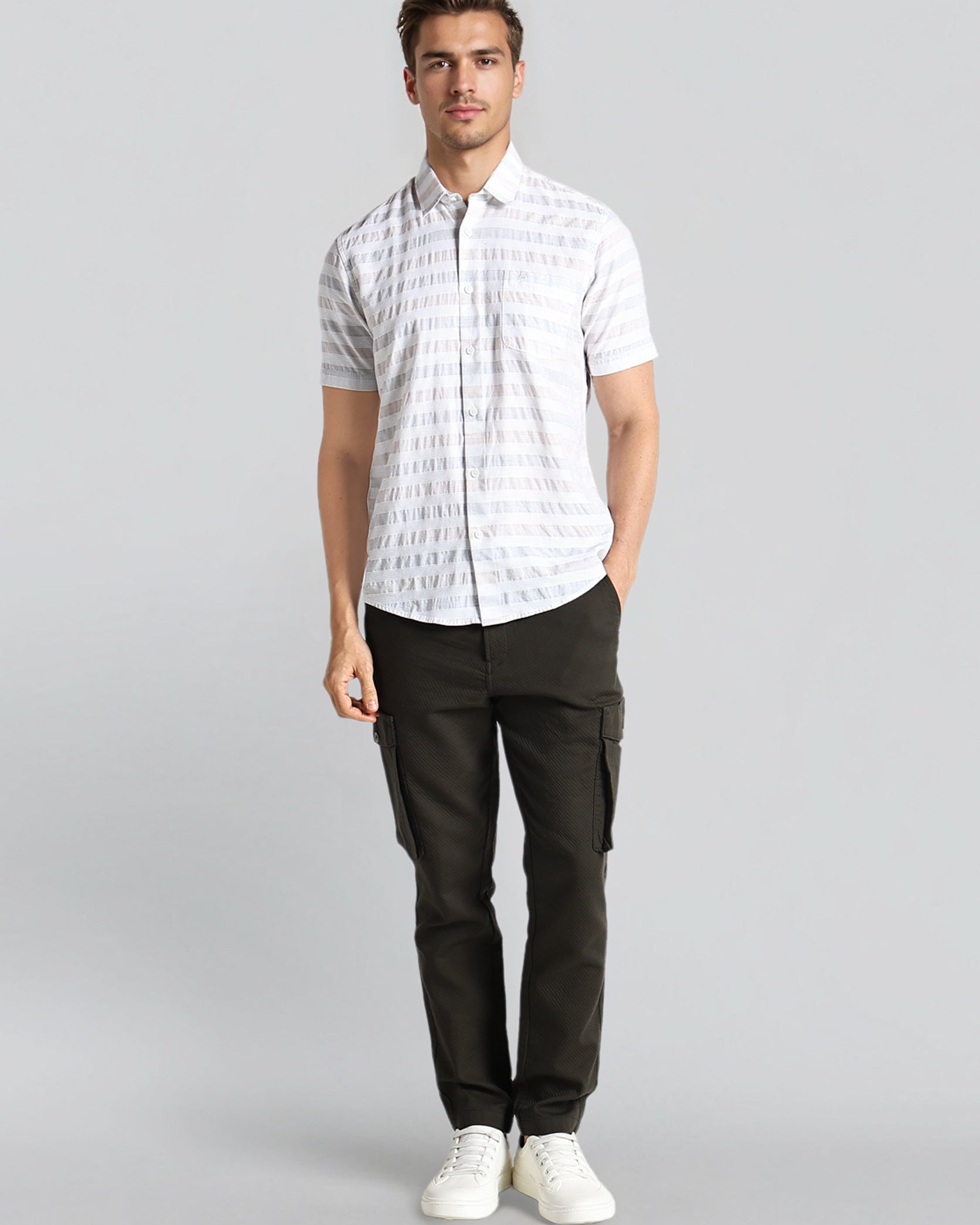 Man wearing a white checkered shirt and black pants on a gray background