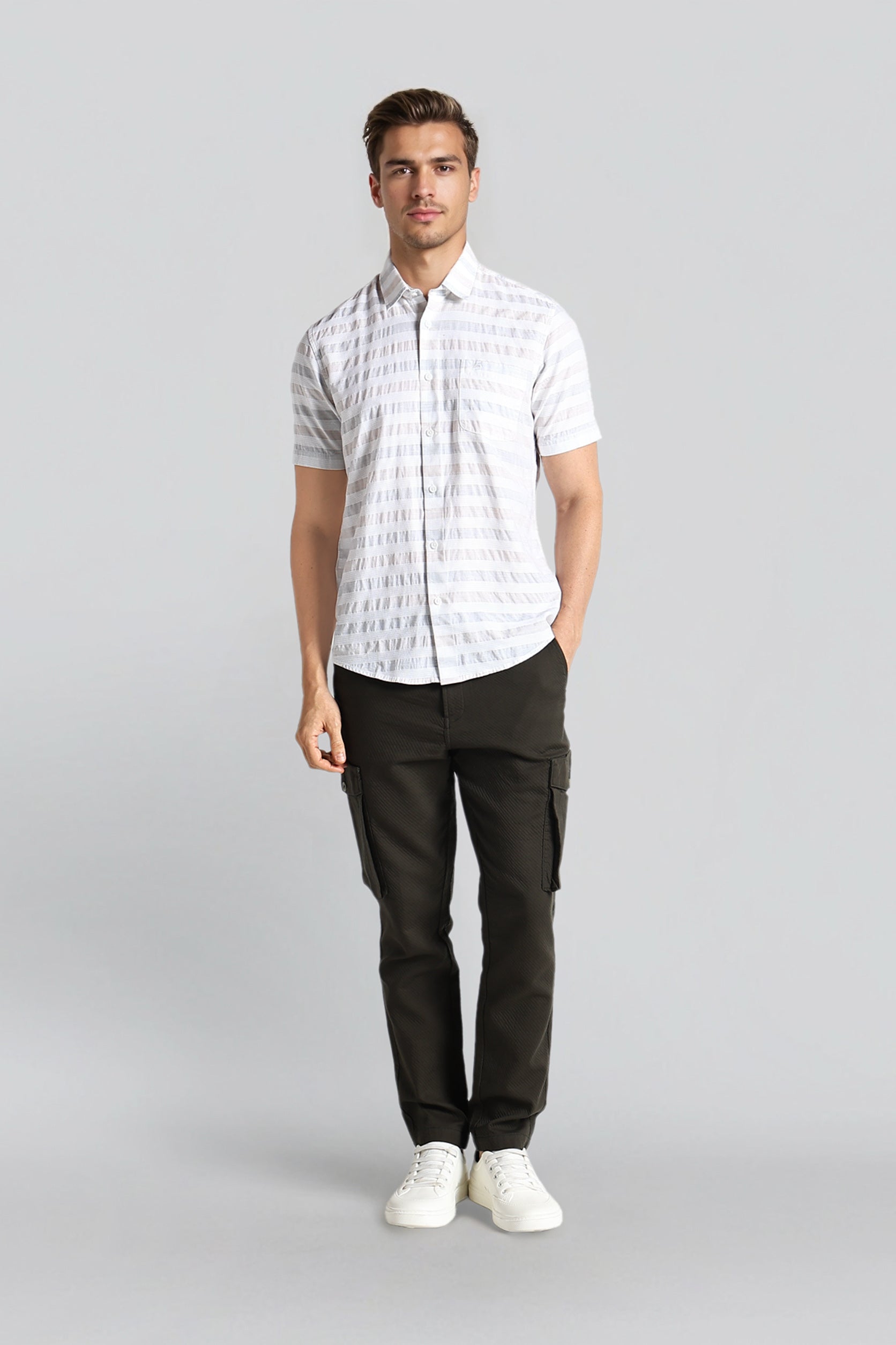 Man wearing a white checkered shirt and black pants on a gray background