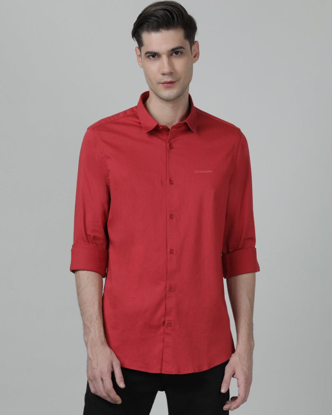 Man wearing a red tomato red solid full sleeve shirt on a light gray background
