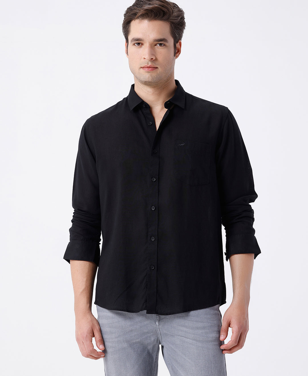 Man wearing a black linen blend shirt in black with casual styling on a gray background