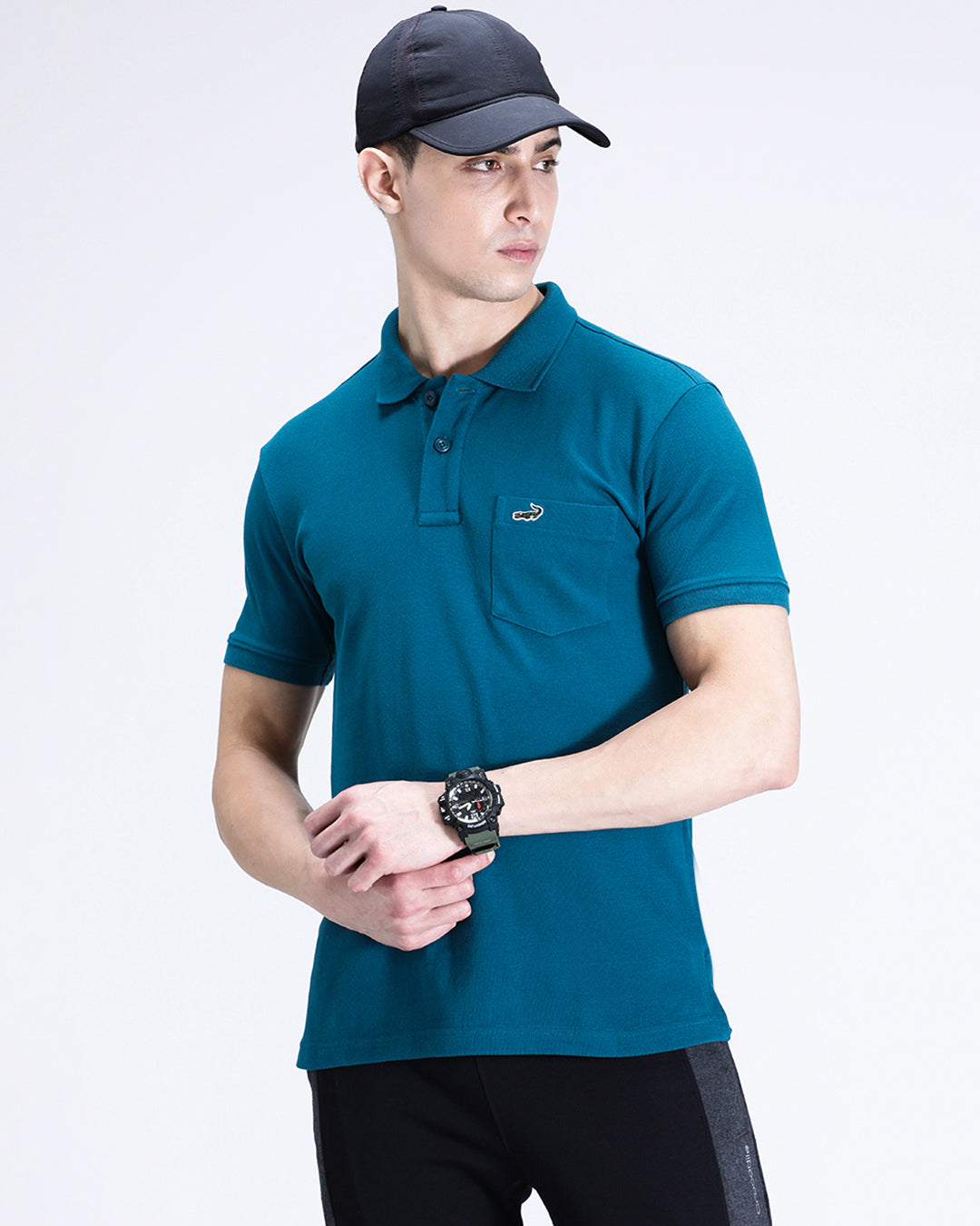 Man wearing a blue blue coral solid polo t shirt with casual styling on a gray background