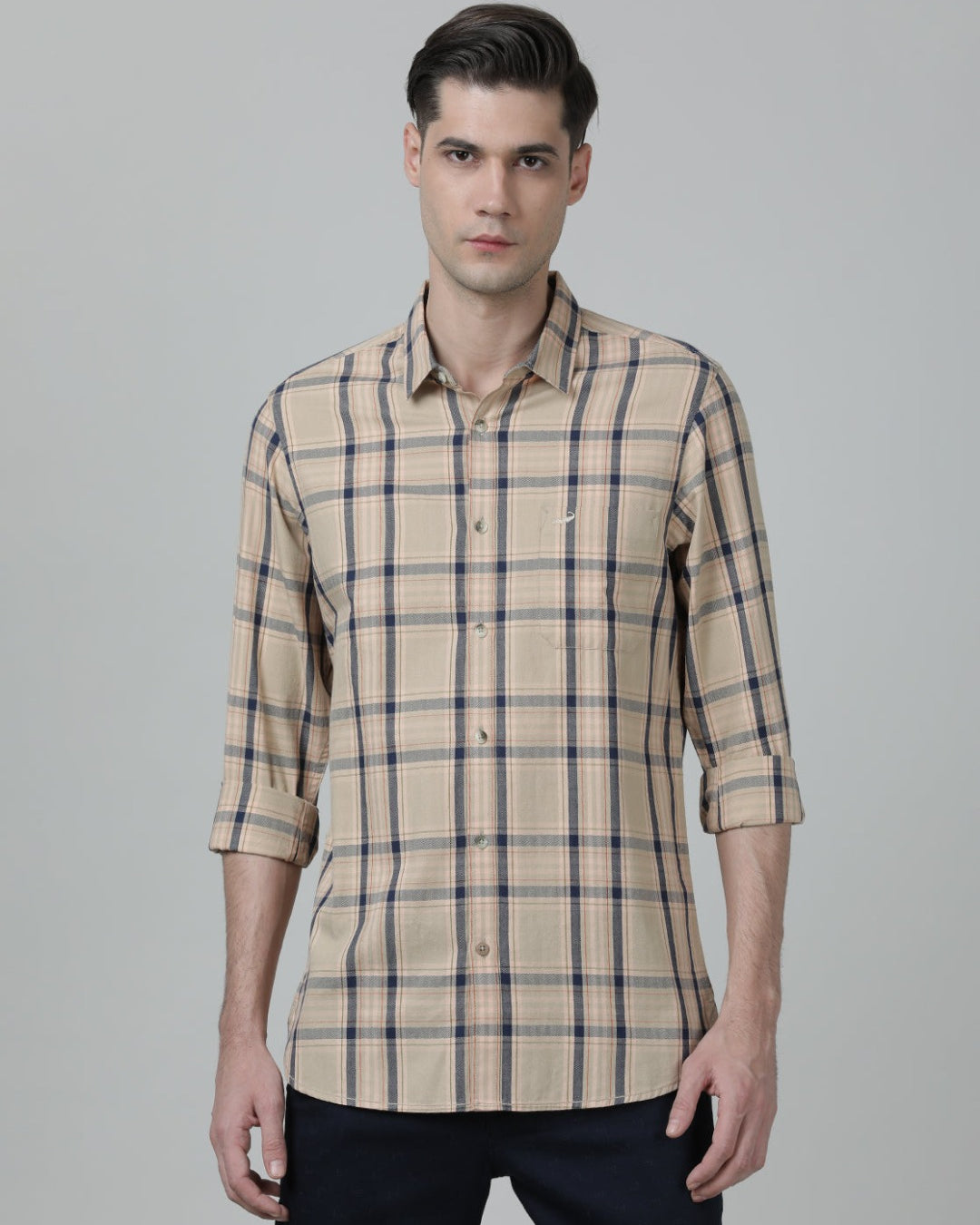Man wearing a beige beige checked full sleeve 100% cotton shirt with casual styling on a gray background