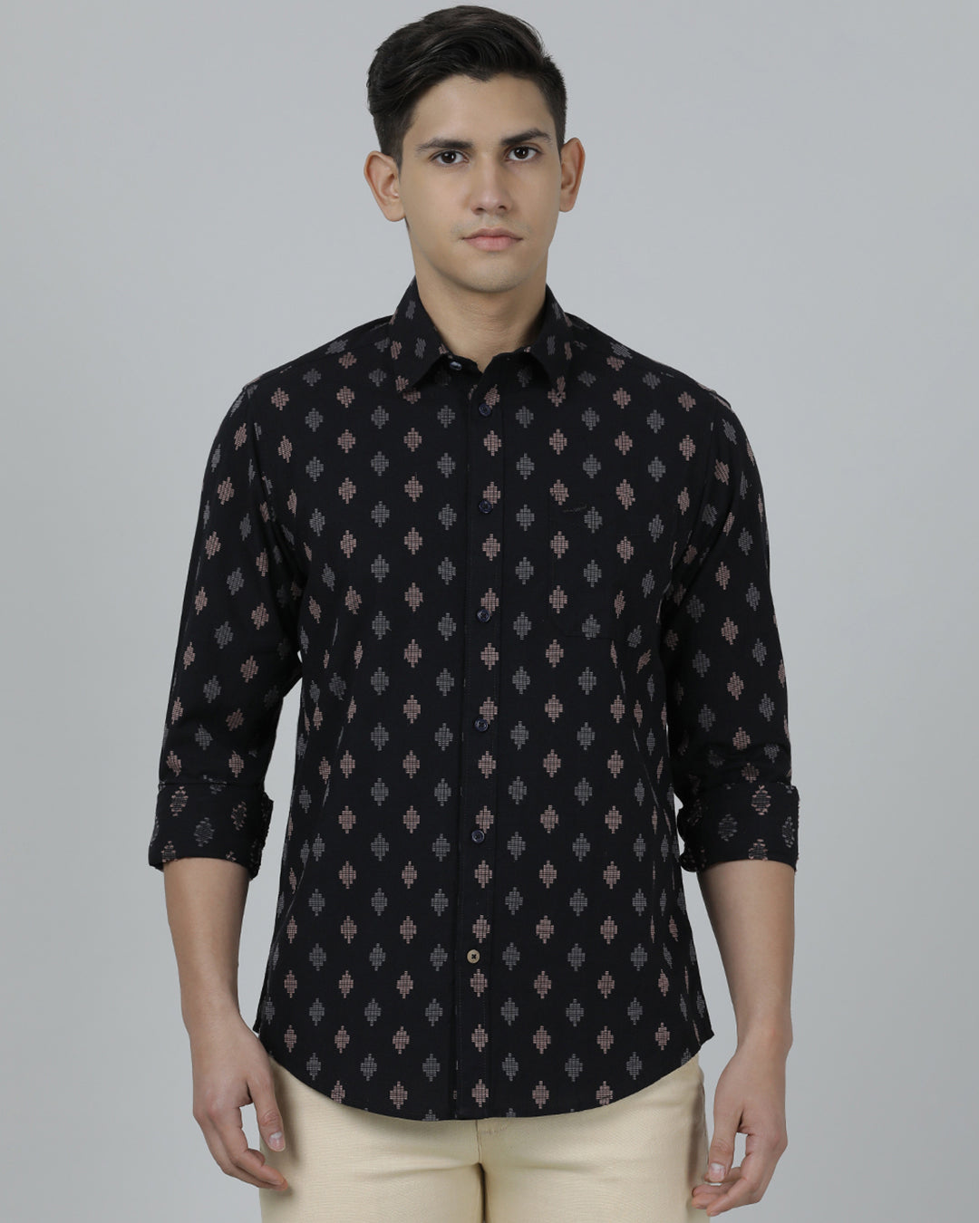 Man wearing a black black printed full sleeve shirt on a light gray background