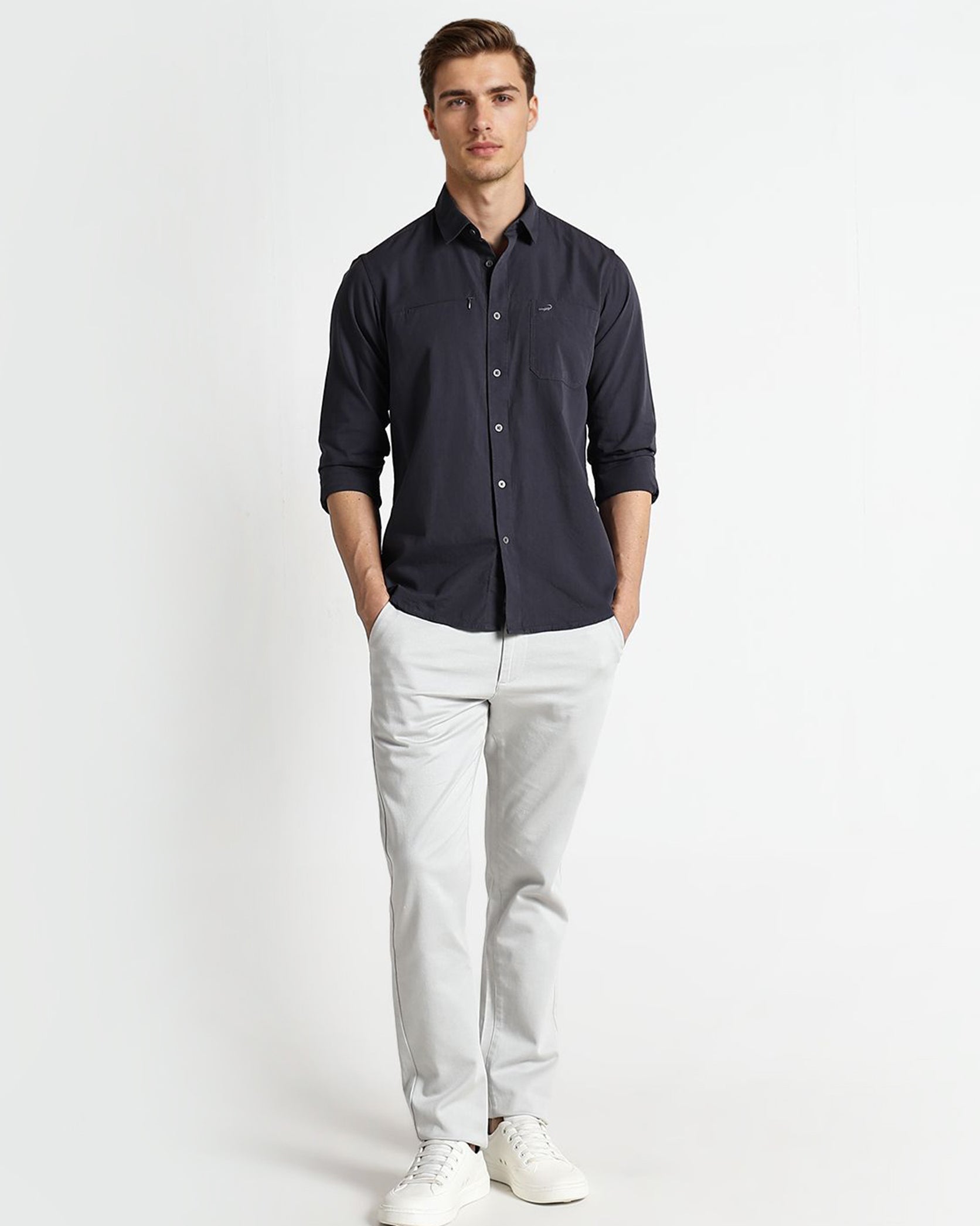 Man wearing a dark shirt and light pants on a white background