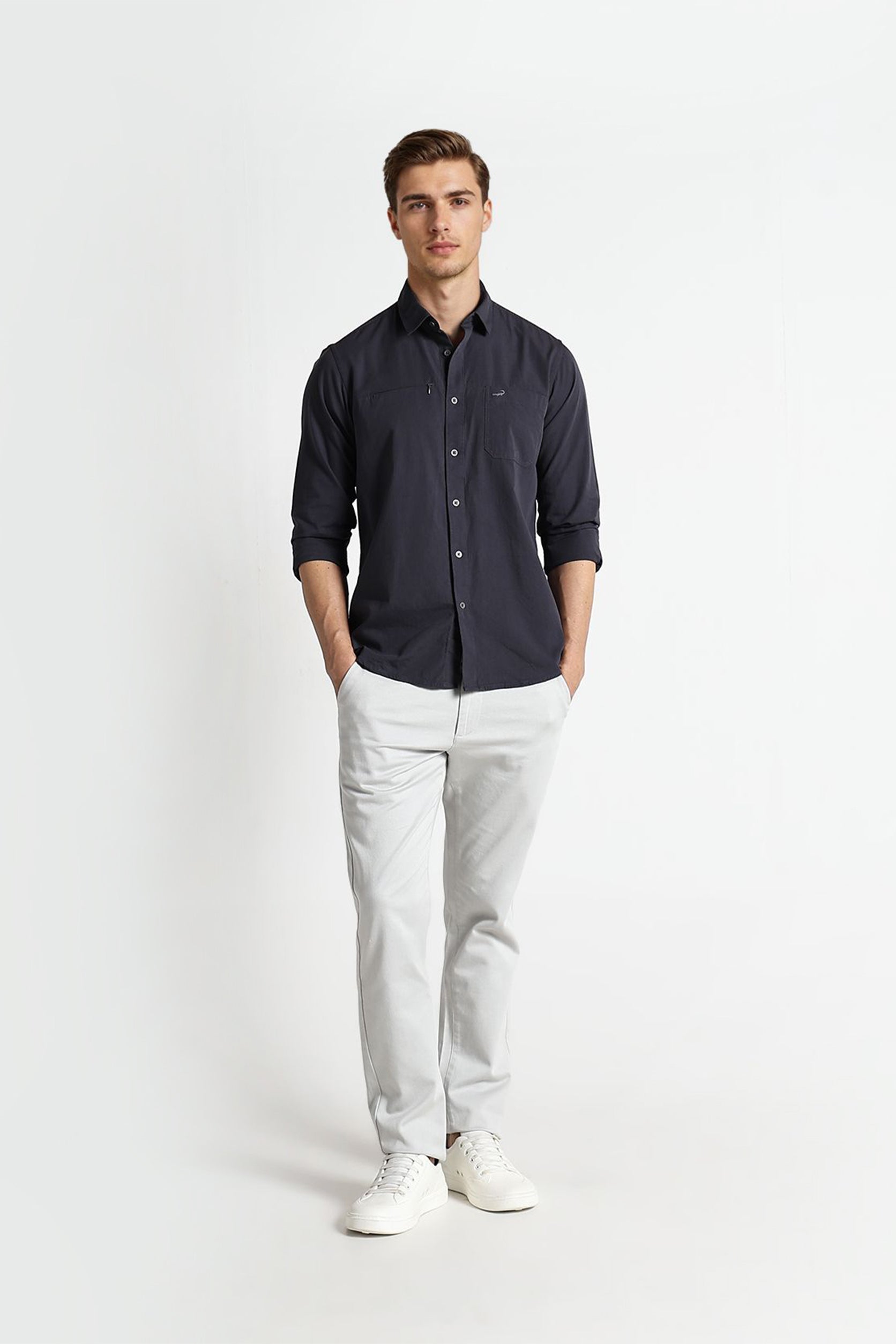 Man wearing a dark shirt and light pants on a white background