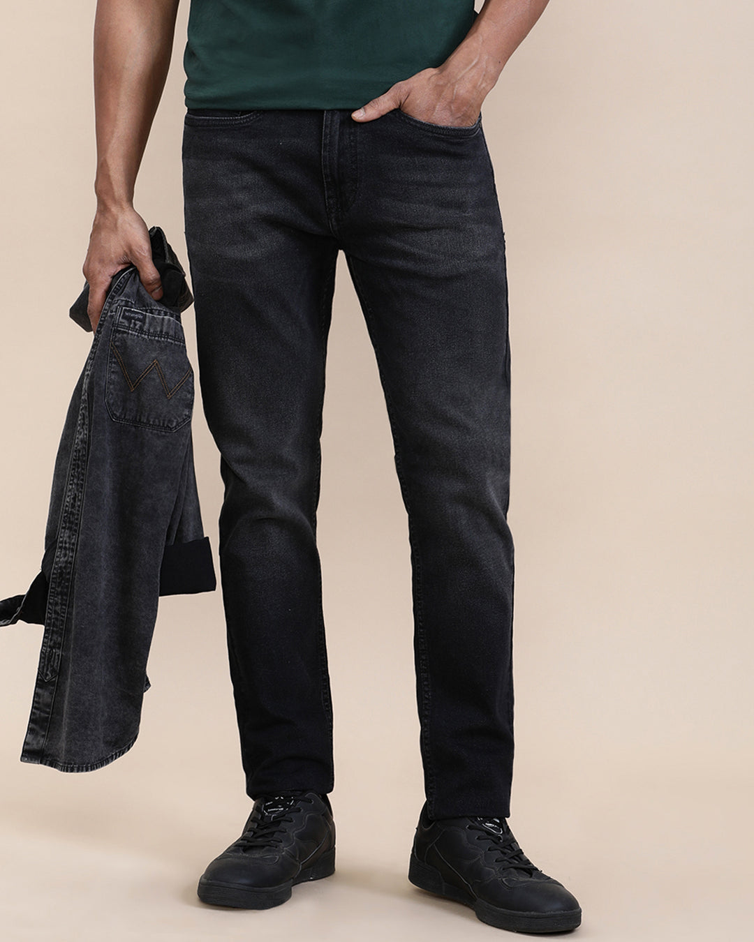 Man wearing a red natural fade wash slim tapered jeans on a light gray background