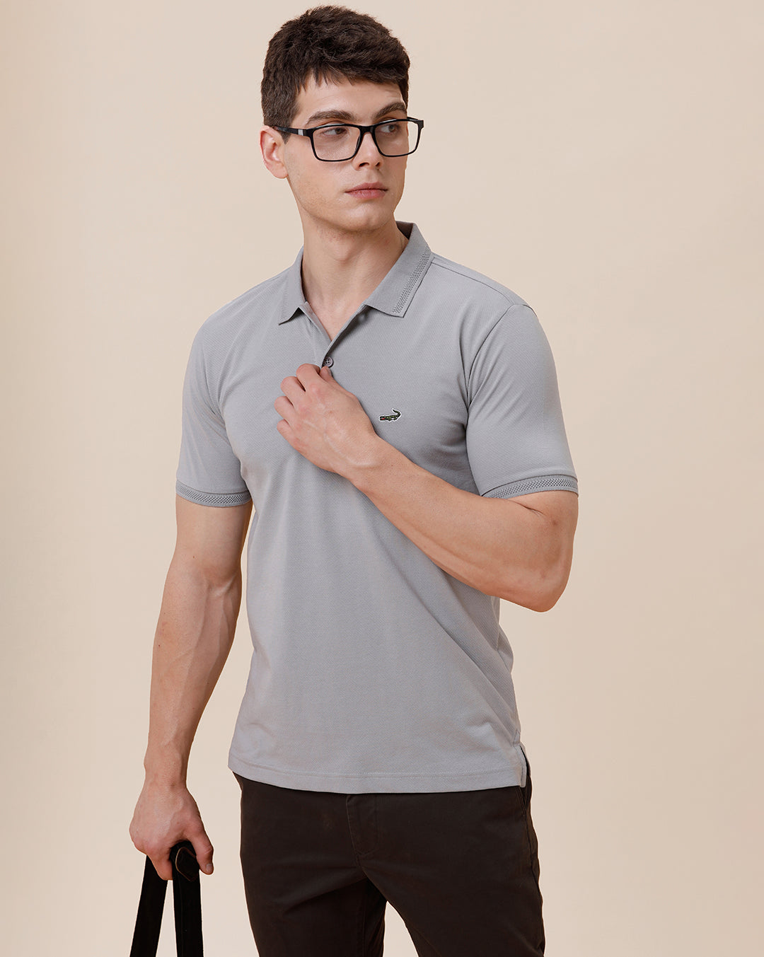 Man wearing a solid half sleeve casual polo t shirt on a light gray background
