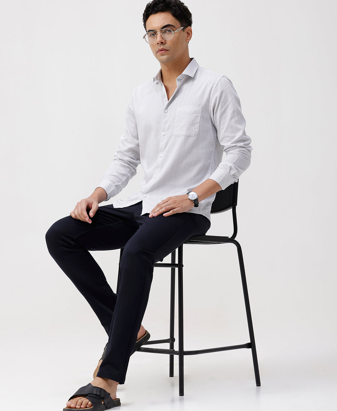 Man wearing a white white all over print slim fit casuals shirts with casual styling on a gray background