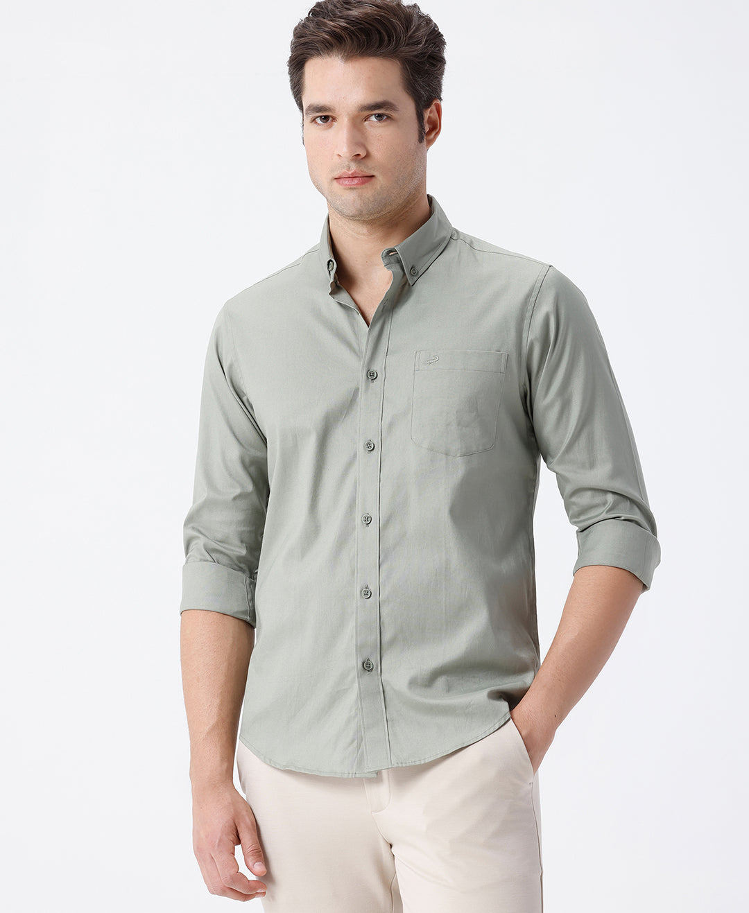 Man wearing a green smart series premium oxford shirt green with casual styling on a gray background