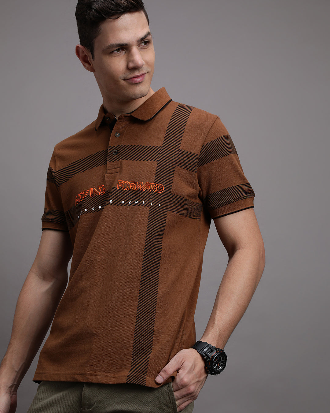 Man wearing a yellow rubber yellow printed polo t shirt with casual styling on a gray background