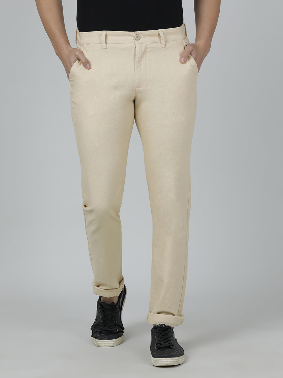 Man wearing a beige solid slim fit casual trouser beige with casual styling on a gray background