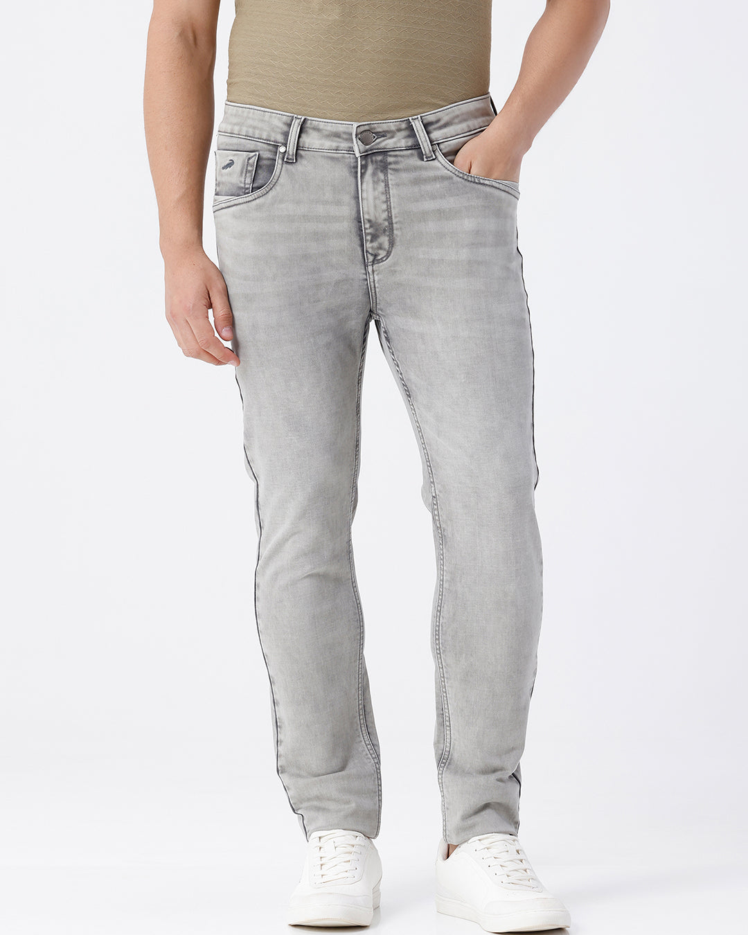 Man wearing a grey light grey knit slim fit jeans on a light gray background