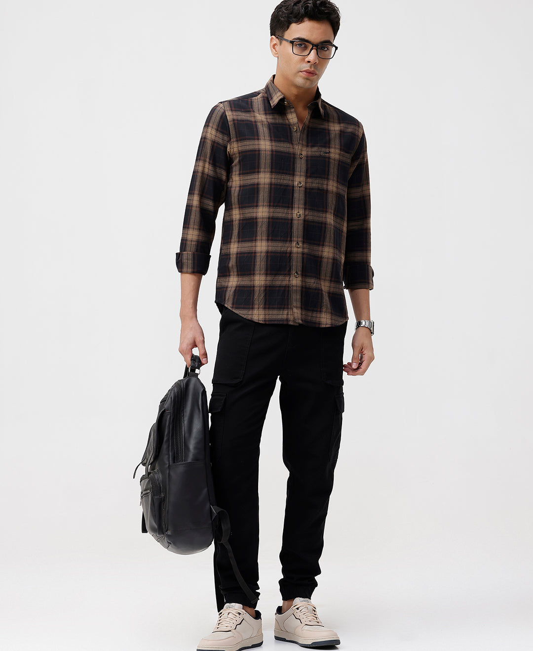 Man wearing a brown oxford checks shirt brown with casual styling on a gray background