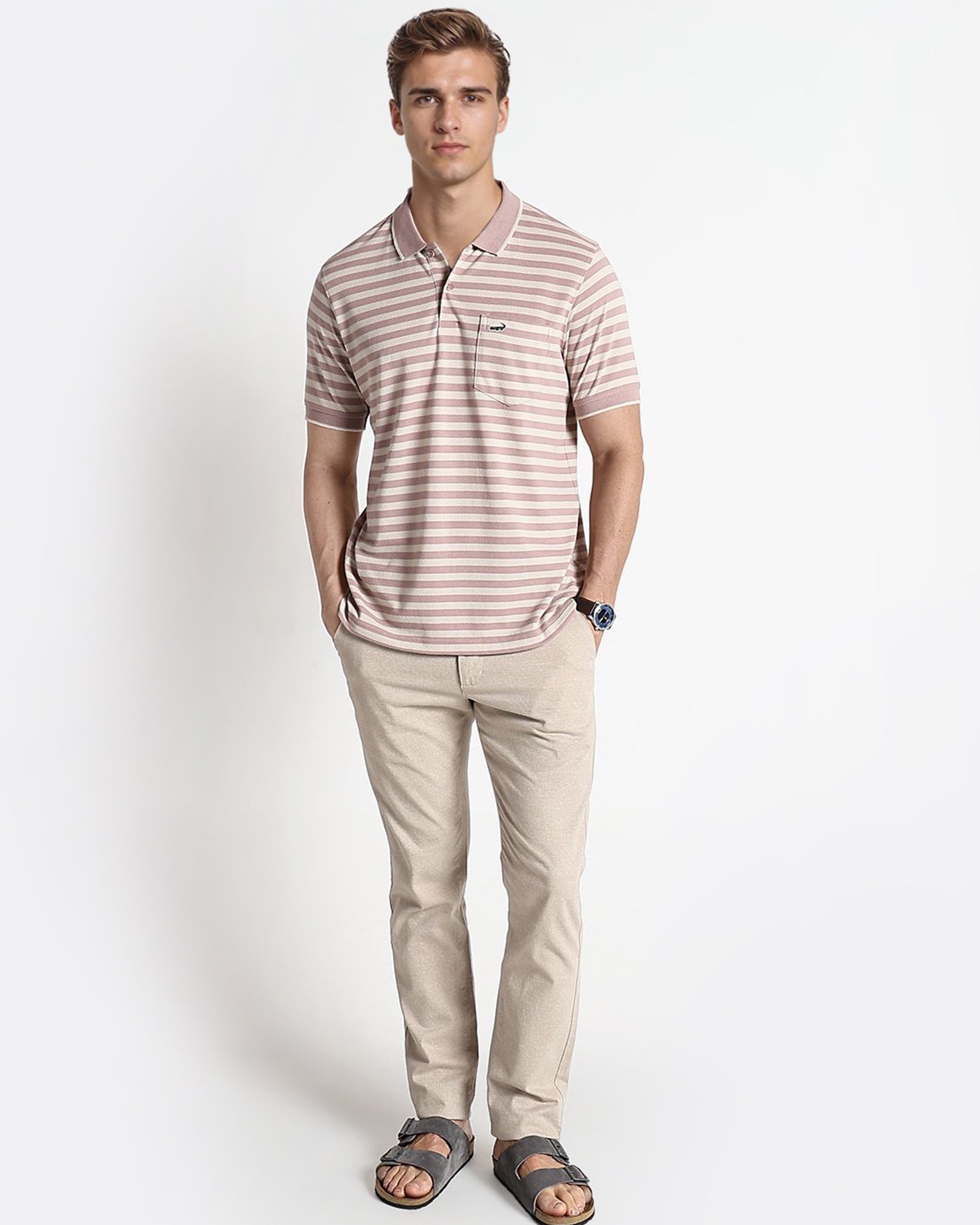 Man wearing a striped polo shirt and beige pants on a white background