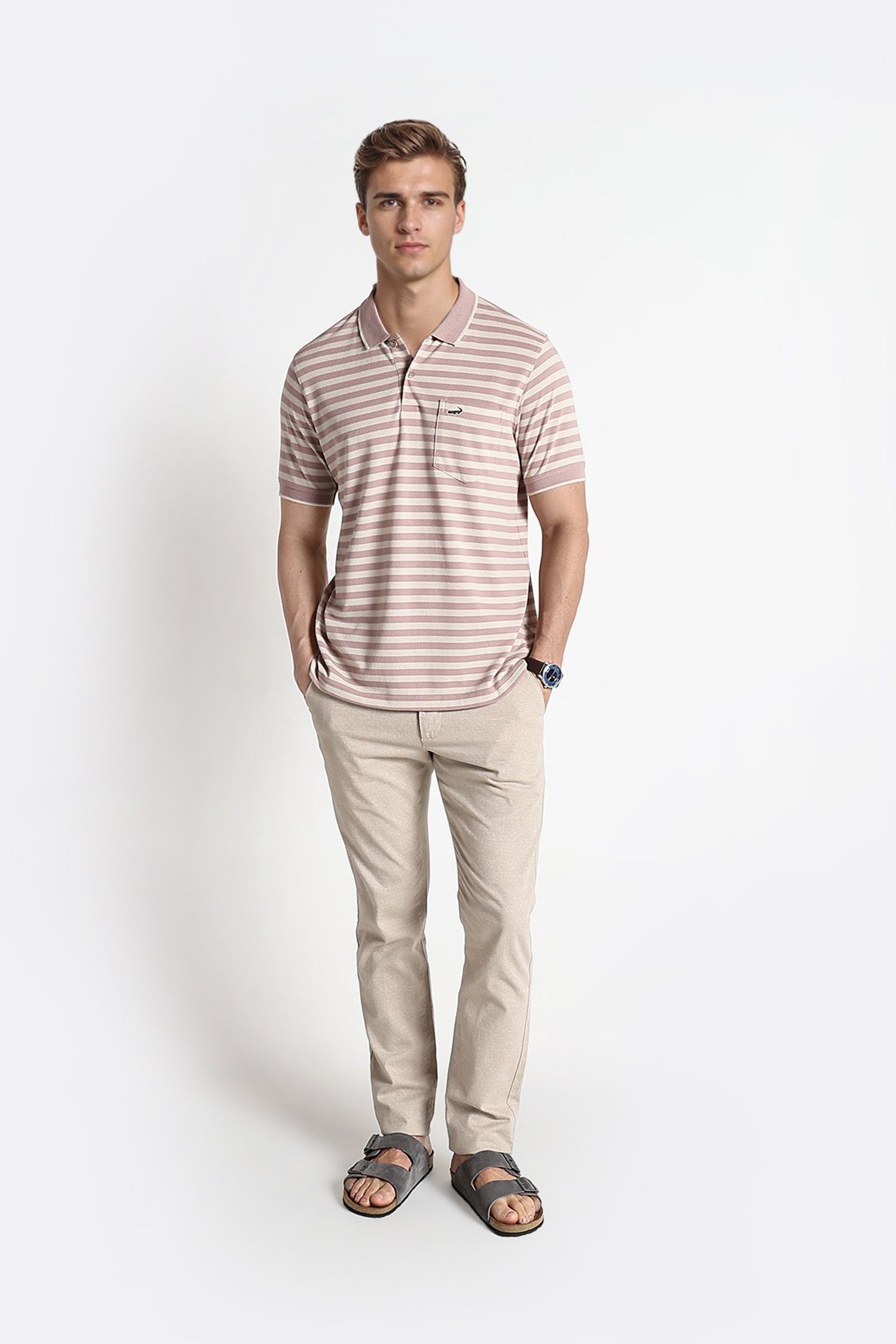 Man wearing a striped polo shirt and beige pants on a white background