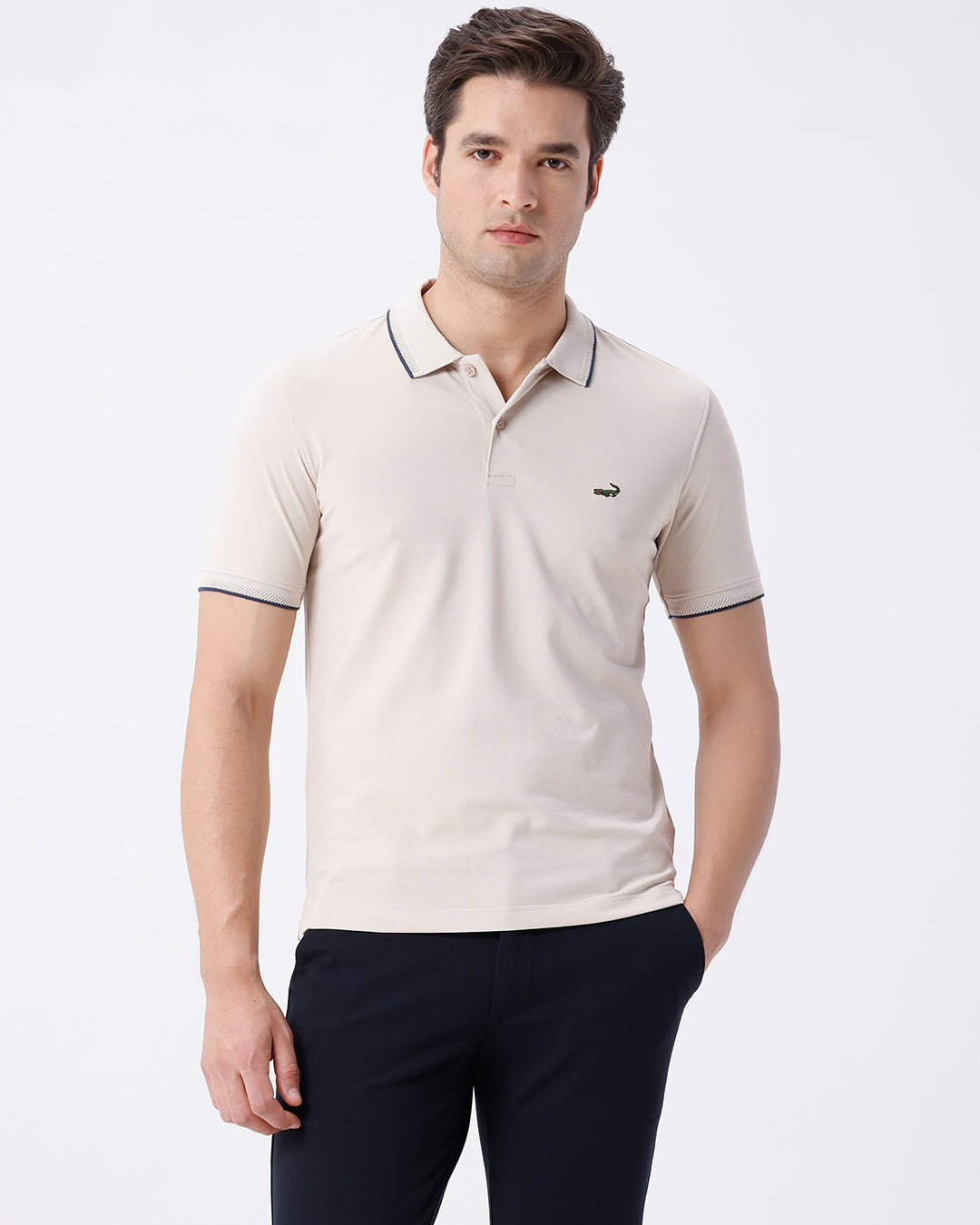 Man wearing a beige breeze stretch polo t shirt beige on a light gray background