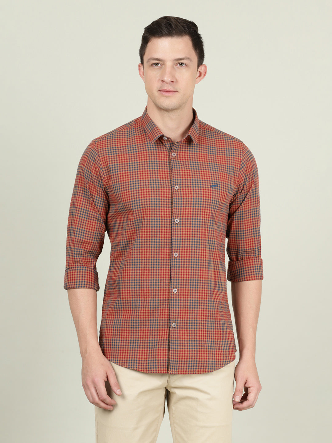Man wearing a red red checked full sleeve casual shirt with casual styling on a gray background