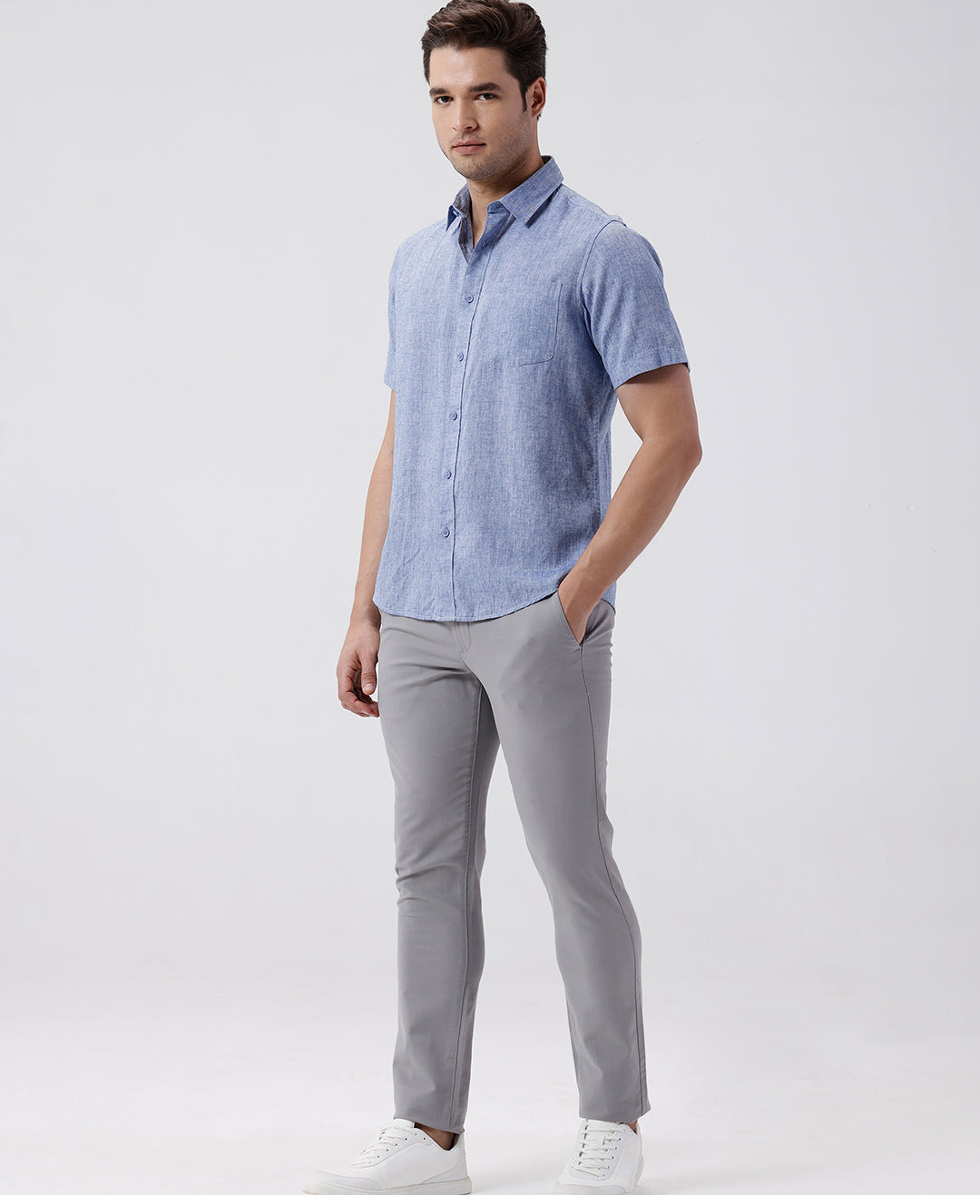 Man wearing a blue premium tensil linen shirt blue on a light gray background