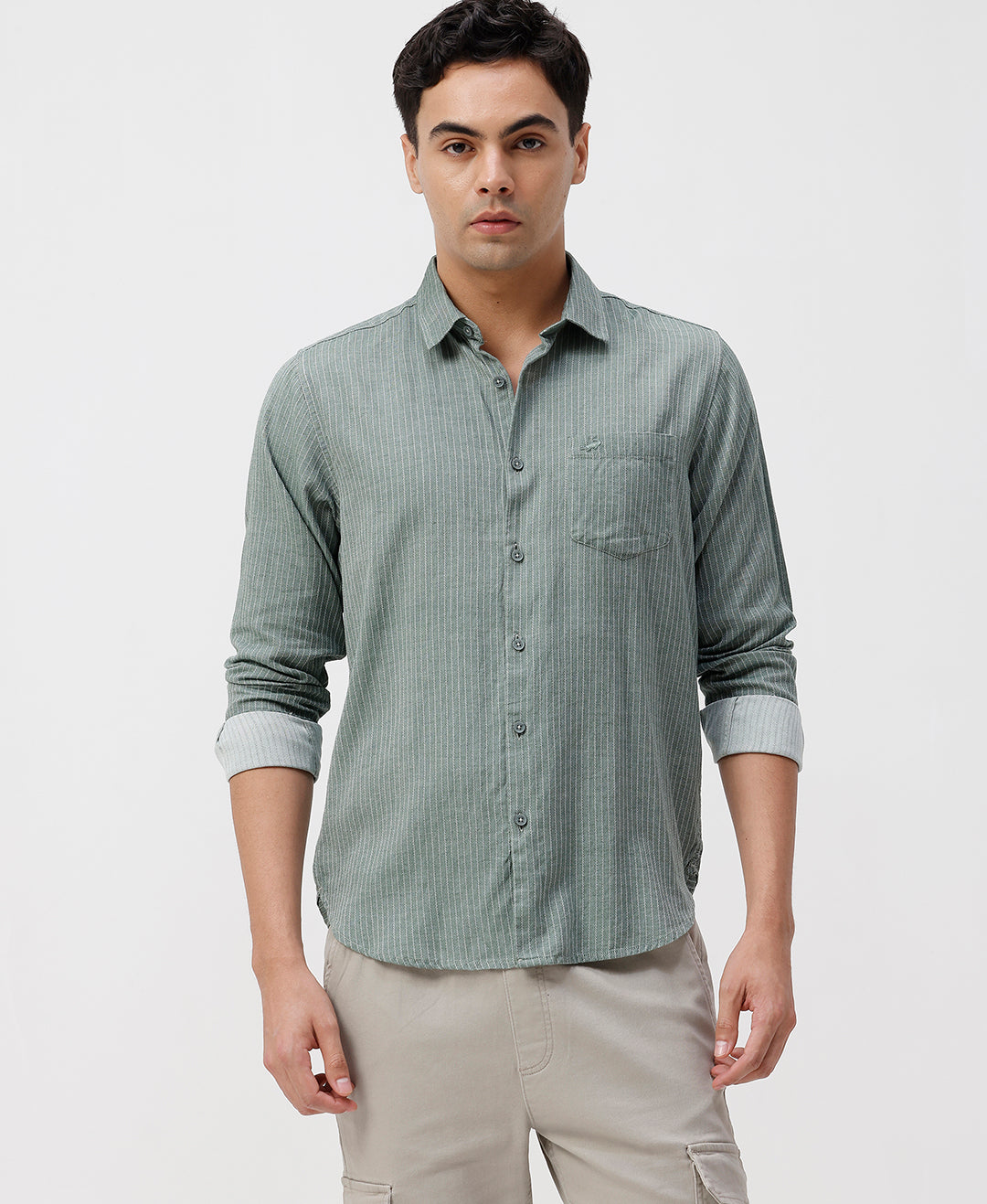 Man wearing a green green striped cotton shirt on a light gray background