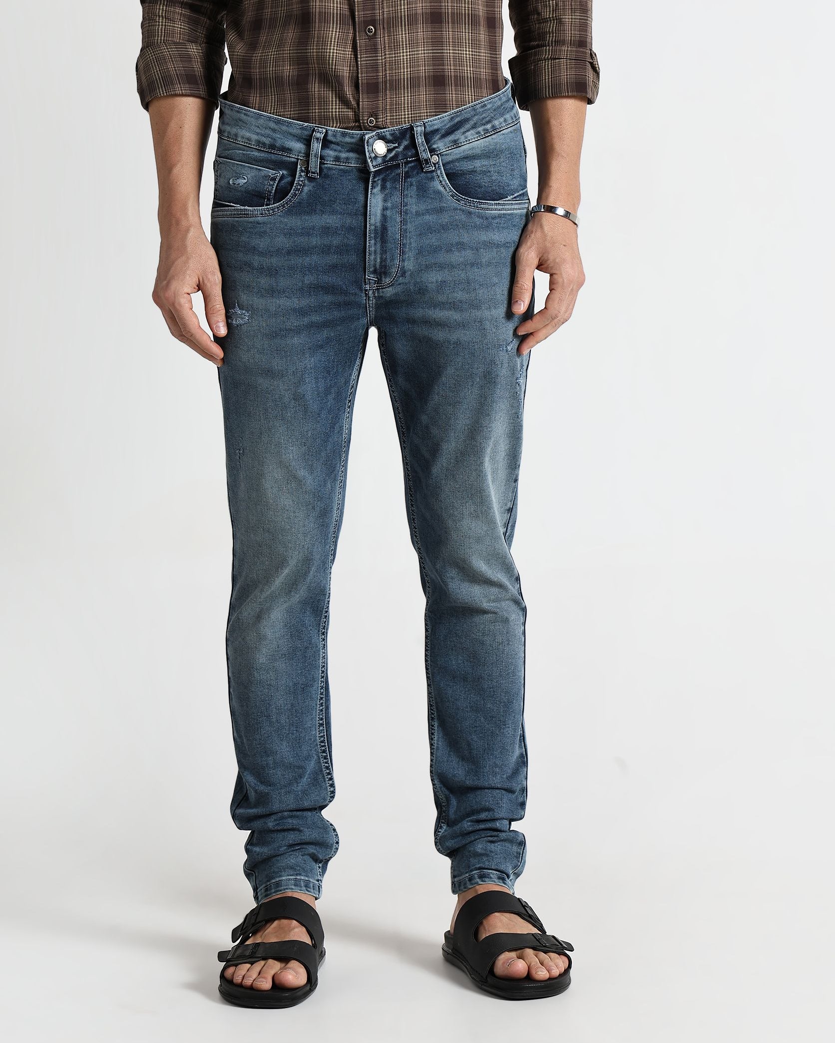 Person wearing blue jeans and a plaid shirt on a white background