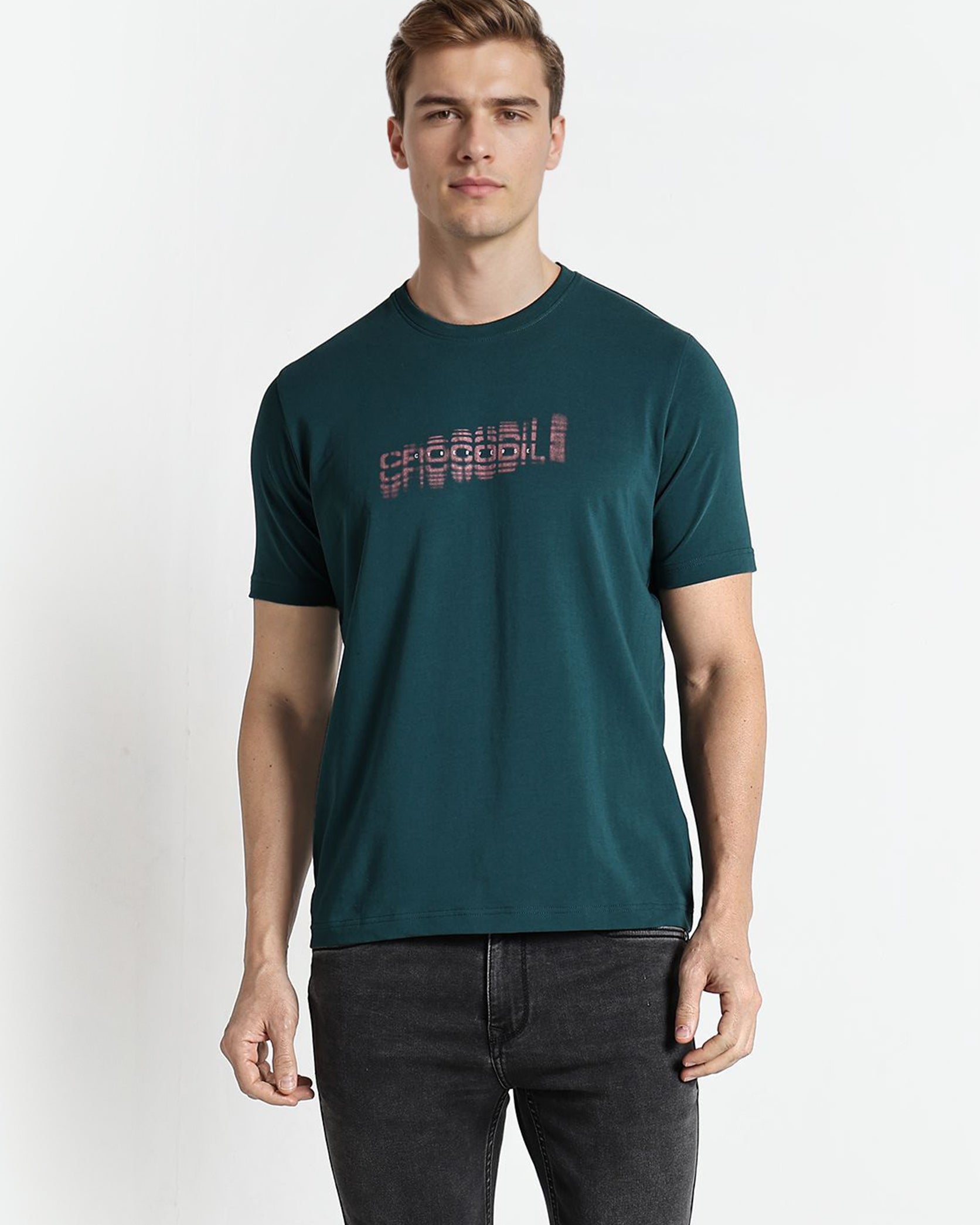 Man wearing a teal t-shirt with red text on a white background